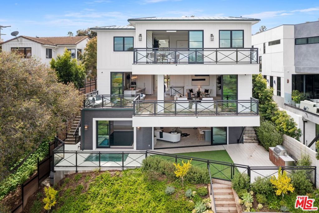 This extraordinary, new FARMHOUSE residence nestled in the Via Bluffs neighborhood of Pacific Palisades boasts spacious living, luxe amenities and an amazing outdoor space. Encompassing 5,900 SF, 6 beds and 5 baths, the home displays exquisite views of the Santa Monica Mountains and Potrero Canyon Park. Inside, the Farmhouse style chef's kitchen in white and a large pantry. Attached is a chic living area with a gas fireplace and a next room formal dining room. Opportunities to luxuriate abound with an indoor pool and outdoor spa, entertainment room and wine room. Outside, find an enchanting, terraced yard with a barbecue, bar and large deck. The primary suite features a large his/hers walk-in closets and a spa-like bathroom. Residents will enjoy a 2-car garage, two laundry rooms. This pristine home beckons a life to live to its fullest, setting a scene of immaculate beauty and amenities.