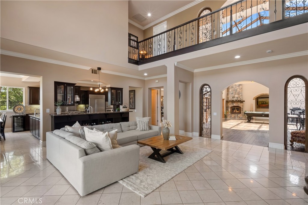 Step into elevated living at 24089 Gold Rush Dr—an exceptional Mediterranean-inspired custom estate nestled on a prestigious corner lot in the hills of Diamond Bar. With nearly 6,000 square feet of refined living space, this 5-bedroom, 5.5-bath masterpiece blends timeless architecture, modern luxury, and an effortless indoor-outdoor lifestyle.
From the moment you enter the gated courtyard, elegance surrounds you—marble floors, soaring ceilings, and a grand chandelier create a stunning first impression. The chef’s kitchen is designed to impress with Viking stainless steel appliances, Sub-Zero refrigerators, granite countertops, and custom maple cabinetry—perfect for preparing gourmet meals or hosting unforgettable dinner parties.
A tranquil Japanese tatami room brings cultural charm and grace, while the showstopping bonus living room invites you to unwind beneath a dramatic glass atrium rooftop, warmed by a floor-to-ceiling brick fireplace—ideal for cozy nights in or sipping wine under the stars.
A sweeping spiral staircase leads to a mezzanine landing and two upper balconies, where you can enjoy your morning coffee while taking in breathtaking panoramic views. Downstairs, the luxurious primary suite offers a spa-like bath with a Jacuzzi tub, perfect for unwinding after a swim in your private resort-style backyard.
Designed for entertaining and everyday joy, the outdoor space features a sparkling pool and spa with rock waterfall, built-in BBQ, and open-air areas perfect for sunset gatherings, weekend parties, and casual poolside lounging.
With four-zone A/C, energy-efficient solar, a three-car garage, no HOA, and low taxes, this home offers unmatched comfort, elegance, and value.
This is more than a home—it’s a lifestyle. A rare opportunity to own one of Diamond Bar’s finest custom estates. Come experience the luxury for yourself.