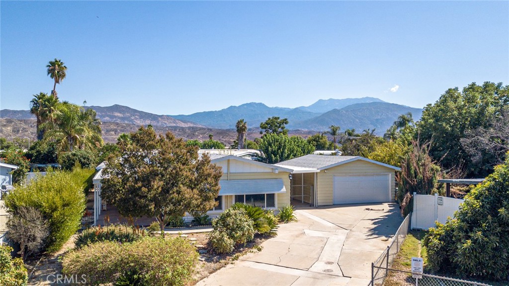 Beautifully renovated and set on its own land with a permanent foundation poured in 2015, this spacious 1,996 sq. ft. Hemet residence offers the perfect blend of comfort, style, and functionality. Featuring 2 bedrooms and 2 updated baths, the home boasts a flowing floor plan with vaulted ceilings, large picturesque windows, ceiling fans, and contemporary lighting. The inviting living room showcases a built-in china hutch and upgraded entry, while the extended family room offers skylights, custom cabinetry, a wet bar with wine rack, and sliding glass doors. The chef’s kitchen is a true highlight with solid hickory cabinetry, soft-close features, pull-out shelving, black-and-white granite counters, breakfast bar seating, stainless steel appliances, designer exhaust hood, and recessed lighting. The laundry room includes matching granite folding space, utility sink, and washer/dryer. Retreat to the spacious primary suite with office/retreat area, walk-in closet, and a spa-like bath featuring dual sinks, refinished soaking tub and shower, and tile floors. A second bath shines with marble counters and designer fixtures. Outdoors, enjoy a breezeway leading to a two-car garage with opener, fenced backyard with fruit trees, and a front yard PVC irrigation system for easy care. Renovated in 2017, this move-in ready home combines thoughtful updates, modern finishes, and everyday convenience—all in a desirable Hemet location.