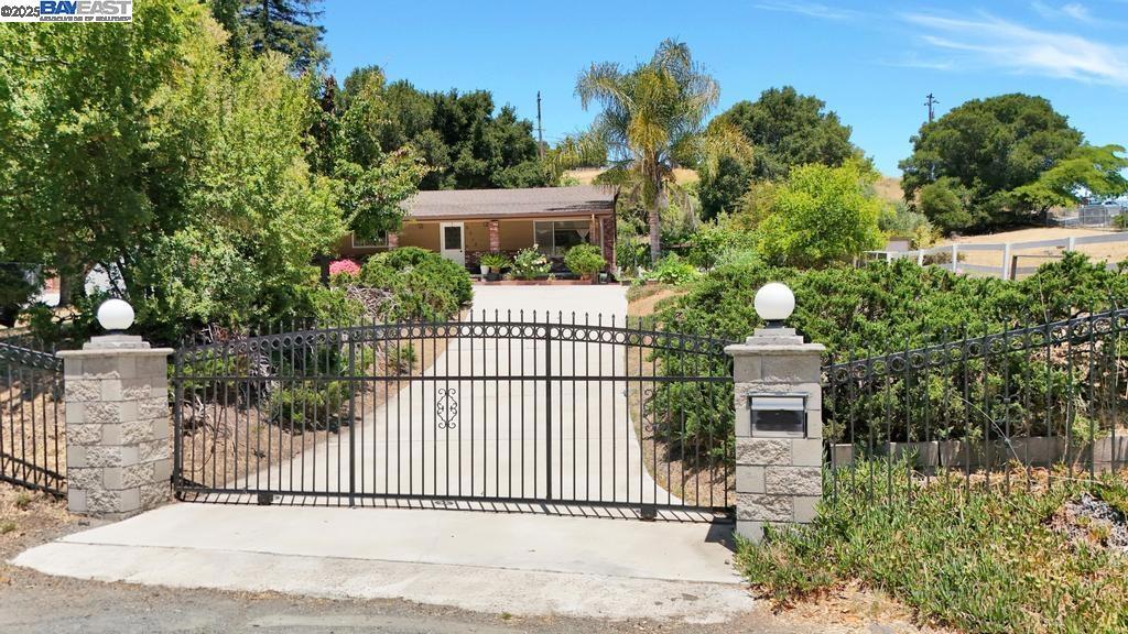 Enjoy a picturesque rustic lifestyle on this 1.6-acre property (consisting of two parcels) with stunning hill and valley views. This charming single-level home features an open floor plan with a seamless flow from the kitchen to the family room, extending effortlessly to a beautifully landscaped yard and pool—ideal for indoor-outdoor living. The property boasts numerous fruit trees, a fenced pasture, and a circular driveway. The main house offers approximately 1,990 sq ft of living space, complemented by a detached 1-bedroom, 1-bathroom guest house of approximately 450 sq ft (built without permits). Situated in a desirable location with strong potential for future lot subdivision—buyer to verify with the county.