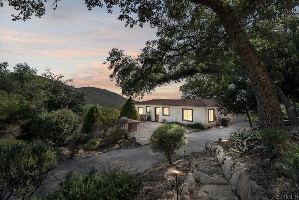 Experience the ultimate in peaceful living on Weststar Ranch just 1 hour from Downtown San Diego. This stunning 2427 sq. ft. residence sits overlooking serene panoramic views on 51.3 private acres. Designed and renovated by a master cabinet builder, the property features a main residence that combines charm with modern comforts, a 2 stall barn with an office and bathroom, a shed, a 20KW Generac generator with auto transfer switch, and 3 private wells. The main well is 1200 feet deep and serves the home and some landscaping. As you drive up you are greeted with a charming stone wall exterior. Inside, a vaulted wood plank ceiling, stone fireplace in the main living area with direct access to the outdoor deck welcome you. The kitchen is well appointed with custom wood cabinets, granite countertops and stainless appliances. The island and pantry cabinets provide lots of storage and workspace for the most ambitious chef’s. A spacious dining room with access to the outdoor deck is perfect for entertaining and hosting holiday parties. The spacious primary suite is flooded with natural light. Downstairs is a large laundry/mudroom and additional room that offers flexibility as a game room, gym, or bonus living space. Outdoors, enjoy the beautiful sunrise and sunset views from the outdoor deck, the quaint sitting areas and many trails that abound on the property perfect for horse or ATV riding or hiking. Zoned S92 general Rule W Animal Designator. Whether you're seeking privacy, self-sustainability, creating an event venue, family compound or a lifestyle retreat--this is a rare opportunity.