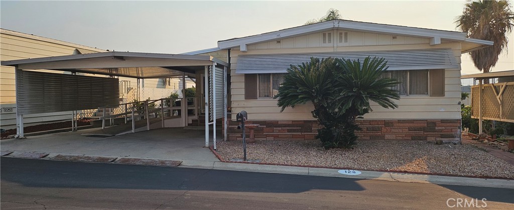 Welcome to this easily accessible and spaciously laid out home in the conveniently located and peaceful community, Villa Magnolia, a 55+ community. This home boasts new carpet and paint while still holding onto its original charm. Multiple windows and a mid floor skylight light lets in plenty of natural light. Spend some time in the cozy sunroom with a book or your morning cup of Jo. Currently the covered carport is equipped with a wheelchair ramp, allowing space for 1 car and golf cart parking. Without the ramp, there is room for 3 cars with 2 parked in tandem. Offering RV parking, a swimming pool for those warm days, sauna, fitness center and conveniently located, Villa Magnolia is the place to be.
