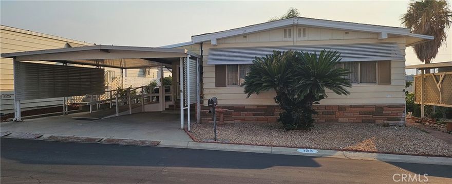 Welcome to this easily accessible and spaciously laid out home in the conveniently located and peaceful community, Villa Magnolia, a 55+ community. This home boasts *NEW* Carpet & Paint while still holding its original charm.  Multiple windows and a mid floor skylight light lets in plenty of natural light.  Spend some time in the cozy sunroom with a book or your morning cup of Jo. Currently the covered carport is equipped with a wheelchair ramp, allowing space for 1 car and golf cart parking. Without the ramp, there is room for 3 cars with 2 parked in tandem. Offering RV parking, a swimming pool for those warm days, sauna, fitness center and conveniently located, Villa Magnolia is the place to be.