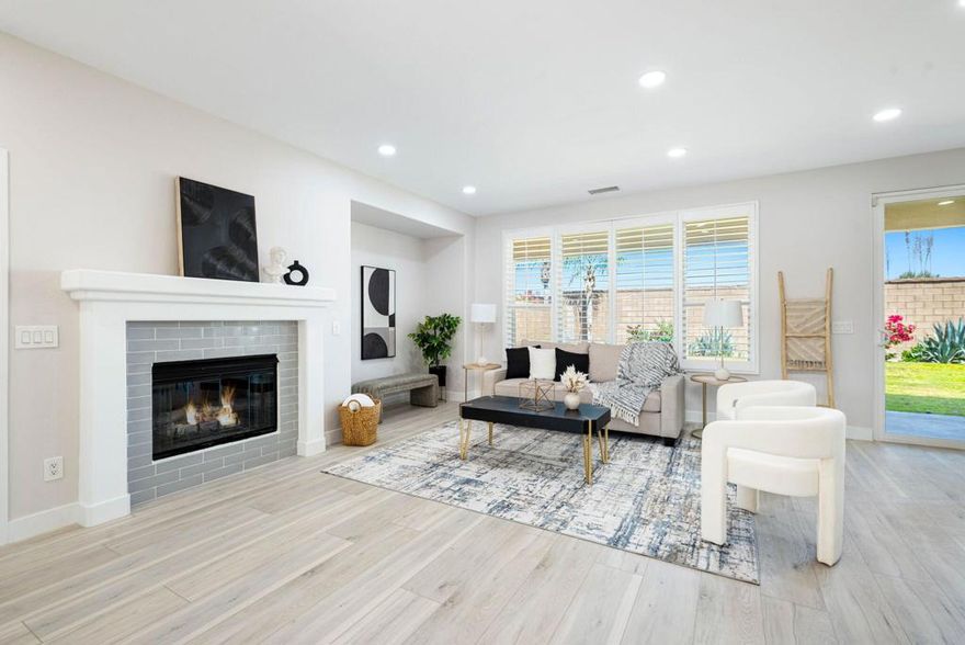 Welcome to Trilogy La Quinta, an exclusive 55+ resort community, where you'll find the epitome of luxury living in this stunning Oasis plan spanning 1580 square feet. This meticulously designed residence features 2 bedrooms and 2 baths, highlighted by a spacious great room adorned with plank flooring and a charming tile-surround gas log fireplace. Plantation shutters and a TV/Media niche add to the ambiance. The dining area is complemented by a hutch cavity and a soothing interior color scheme. The adjacent Chef's kitchen is a culinary haven, boasting granite counters, a peninsula with bar seating, black appliances, a prep island, pantry, and a gas range. Guests will enjoy their accommodations with a nearby full bath featuring a quartz counter, back-lit mirror, and shower-over-tub configuration. The primary retreat offers a slider to the back patio and an en suite bath complete with a dual vanity, large shower enclosure, and spacious walk-in closet. For added convenience, a separate laundry room with cabinetry is included. Outside, the rear yard presents a blank canvas with an extended covered patio and expansive views. Enjoy quick access to the Santa Rosa Clubhouse and its plethora of amenities and activities, just a short 5-minute golf cart ride away.