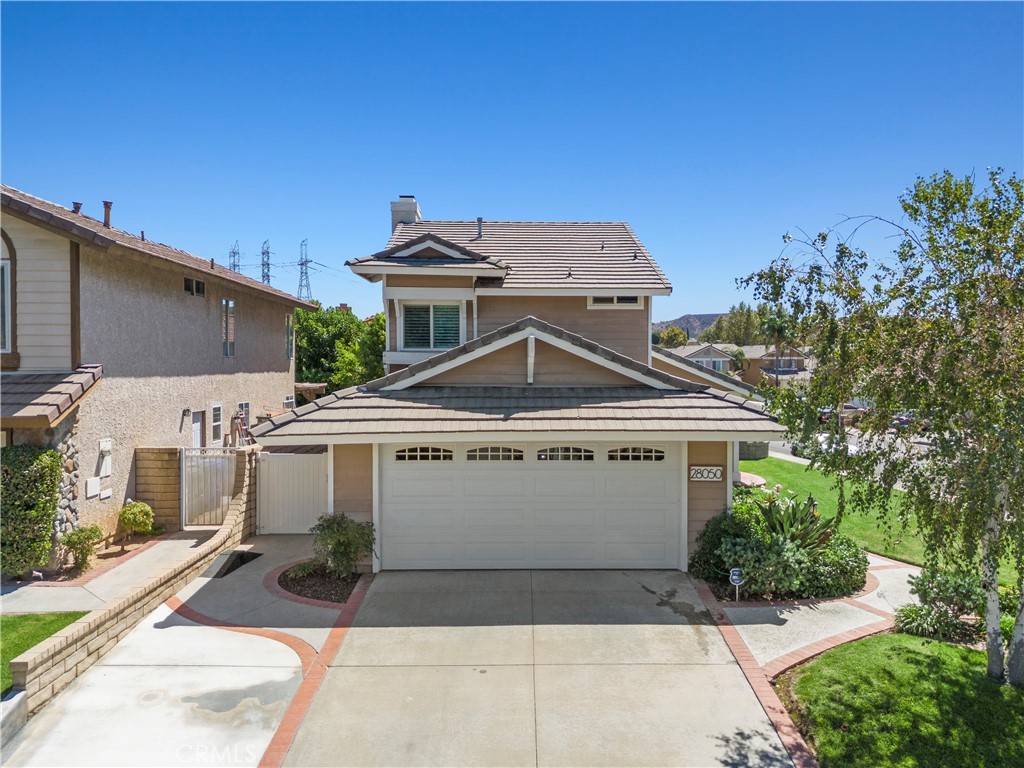 GORGEOUS MOVE-IN READY SAUGUS DREAM HOME! This pristine corner-lot gem radiates pride of ownership and tasteful, modern style! A sprawling green lawn and mature shade tree welcome you, complemented by a charming brick ribbon walkway and driveway, plus a cozy shaded porch! Step inside to soaring ceilings, abundant natural light, and beautiful neutral wood-like flooring throughout the main level. The inviting living room opens to the backyard through sliding glass doors, as does the adjacent dining room—perfect for gathering with family and friends. The cozy family room features a light stone fireplace and flows effortlessly into the bright, modern kitchen, showcasing crisp white cabinetry, granite countertops, recessed lighting, stainless steel appliances, a walk-in pantry, and a sunny window with backyard views. A versatile main-floor bedroom and full bath are ideal for guests, a home office, or multi-generational living. Upstairs, two secondary bedrooms offer closet space and share a full bath, while the primary suite impresses with raised ceilings, a walk-in closet, and an ensuite bath with dual vanities and a shower/tub combo. The backyard offers plenty of potential, complete with a green lawn, brick planter boxes, a concrete patio with brick ribbon detailing, and durable vinyl-and-brick fencing. Additional highlights include laundry in the garage and a prime location near parks, schools, paseos, shopping, dining, and easy freeway access. This is the perfect blend of comfort, style, and convenience in one inviting package, ready for you to move in!