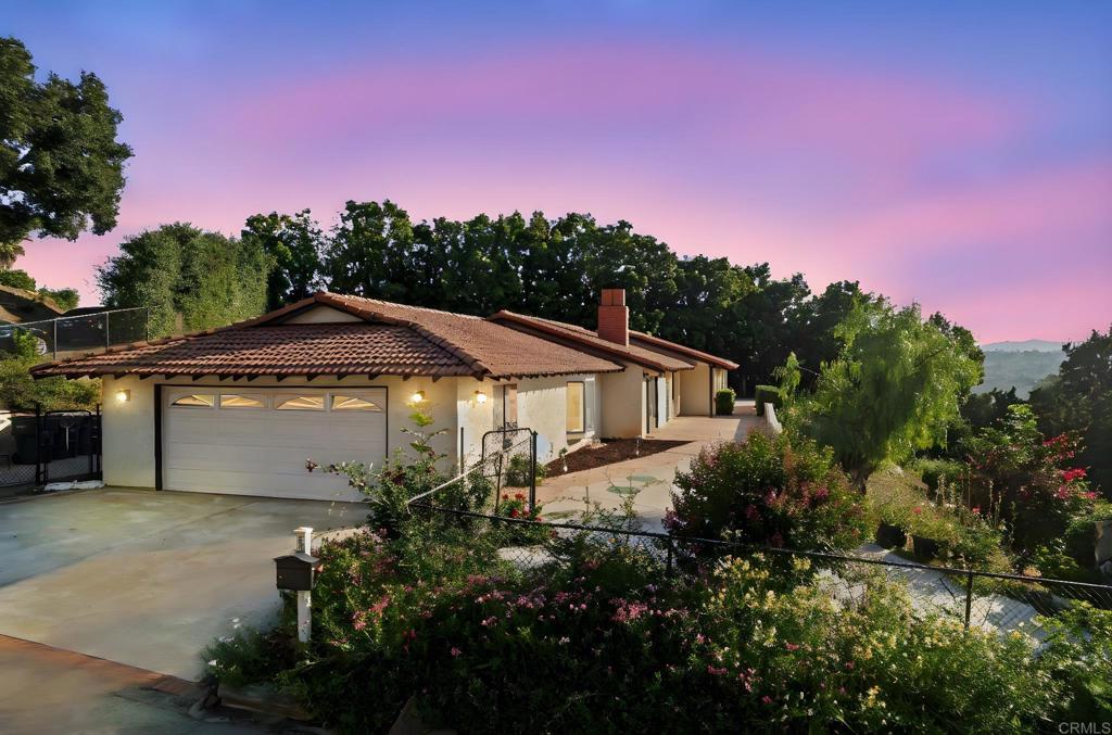 Welcome to your own private retreat nestled in the scenic hills of South Escondido! This single-story home sits on a .79-acre fully fenced lot near the end of a private road in the tranquil San Pasqual Valley. Offering stunning sunset views, you can enjoy peaceful seclusion with the convenience of nearby amenities. Step inside to find fresh interior paint, new carpeting, recessed lighting, and large windows that flood the home with natural light. The floor plan features three spacious bedrooms, two and a half baths, an office, a utility room, and a versatile bonus room—perfect for a gym, playroom, or creative space. Enjoy the gas log fireplace that warms both the living and dining areas, or gather in the expansive family room with a built-in bar and bay window. The dedicated office features custom built-in desk and shelving, ideal for working from home. The main suite offers dual closets, a linen closet, dual vanity, a custom-tiled walk-in shower, and direct access to the backyard for easy indoor-outdoor living. Entertain effortlessly on the covered patio with a built-in outdoor kitchen, surrounded by mature trees, flowering plants, and fruit trees that create a serene, garden-like atmosphere. The lower level of the property, accessible from the street, provides ample space for a pool, ADU, RV pad—or all three! Additional highlights include a newer HVAC system, and extra gated RV/boat parking. This private neighborhood is just minutes from shopping, dining, and recreation. Conveniently located near North County Mall, I-15, San Diego Zoo Safari Park, and popular outdoor destinations like Lake Hodges, Elfin Forest, and the Coast to Crest Trail. This area is served by the Escondido Union School District, with nearby access to LR Green Elementary, Bear Valley Middle, San Pasqual High, and also Classical Academy and Del Lago Academy. Whether you're dreaming of expanding, relaxing, or entertaining—this versatile property is ready for your finishing touches!