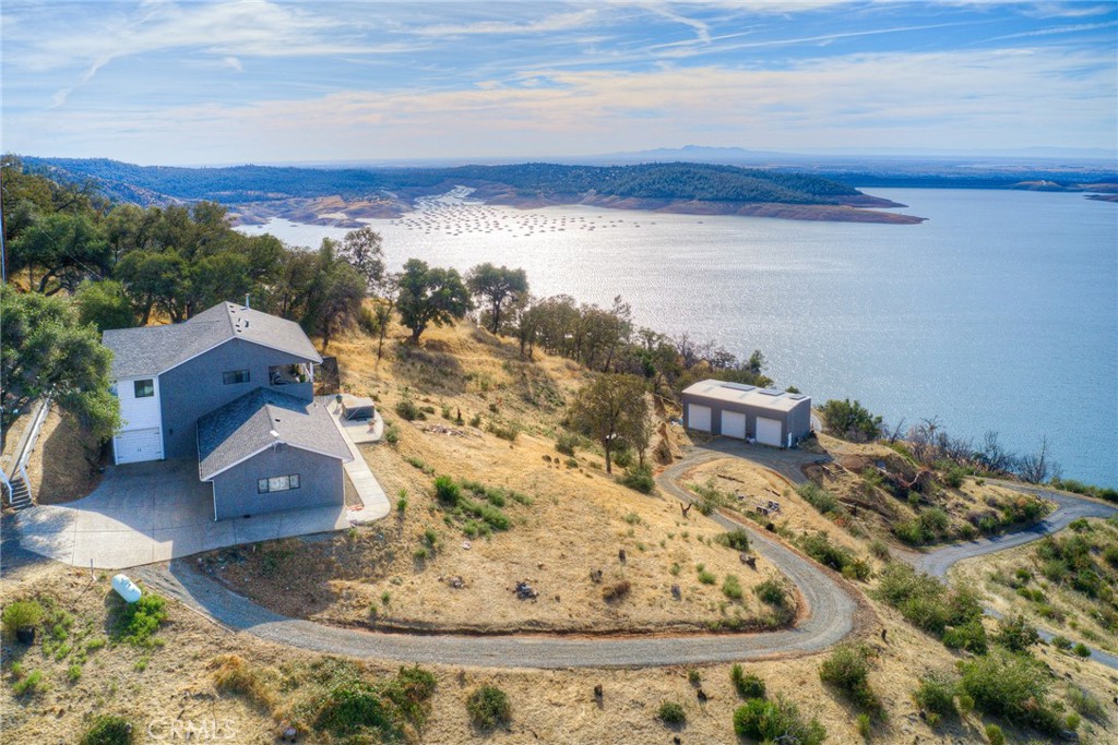 Tastefully remodeled, This upscale home with a breathtaking views of Lake Oroville! This home has over 3200sq ft of living space and sits on 15.17 acres , Some of the great features and the stunning craftmanship are:A gourmet chef's dream kitchen with gorgeous high-end range/stove with a pot filler faucet. The living room has a wood stove and a sliding glass door that leads to a tiled deck that overlooks vast lake views. Both the upper and lower decks are plumbed with propane for accessibility for buyer's entertaining needs. The lovely primary suite has a sliding glass door to the deck, barn doors that lead to the primary bathroom, which has a large walk-in closet, heated floors, double sinks, a walk-in shower with two showerheads, and a large soaking tub. Downstairs you'll find a comfortable living area with 2 additional bedrooms and a full bathroom along with a pet room which has a doggie door to the exterior and a pet cage outside. Your pets can be safely and warmly inside and still be able to go outside as needed.attached standard 2-car garage, a second attached 3-car deep single wide garage and a 30x60 shop ! The shop is a Butler built, red iron shop with top of the line rated insulation. It has high bay apx.20 feet tall and 3 roll up bay doors with 2 man doors. The property has a septic tank and a well which also includes an additional 1250-gallon tank for storing extra water. The property has 3 gates. The first gate is to the lower property, the second is to the shop and the third gate is to the house and is shared with a neighbor. Imagine yourself in this home that exhibits tranquility, style and a much More. dont delay call today for more info 530-828-2902