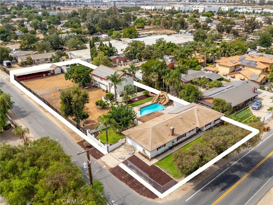 2 Homes – Discover this rare opportunity to own 2 homes on one expansive 0.78-acre lot, complete with horse facilities, a heated pool, and 50 paid-off solar panels to power both homes. FRONT HOME - 1,774 sqft. This beautifully remodeled 3-bed, 2-bath residence features a new 30-year cool roof, whole-house fan, Travertine tile floors, new carpet, fresh interior and exterior paint, upgraded interior doors, full replumb, and ceiling fans in the living room, dining room, and each bedroom. The stunning kitchen features custom Hickory cabinets, Corian countertops with full backsplash, Corian sink, Viking 6-burner gas cooktop with Proline hood vent, and high-end GE Profile appliances: double convection ovens, dishwasher, and refrigerator. The family room features a wood-burning fireplace. The dining room and living room each feature a sliding glass door to the backyard. The main bedroom includes mirrored closet doors, sliding glass door to the backyard, and a remodeled ensuite bathroom. Both remodeled bathrooms include oak pullman vanities with soft-close doors, quartz counters, and designer shower tiles. The main bath has a custom glass shower door, and the hall bath has a new enamel bathtub. The 2-car garage is drywalled and features custom cabinets, a workbench, and a dedicated laundry room with custom cabinets and laundry sink. The backyard feels like your own private resort with a heated pool and spa, rock waterfall and slide, shuffleboard court, regulation horseshoe pits, and a covered patio surrounded by lush landscaping and citrus trees. SECOND HOME - Built in 2008 with permits, this luxurious two-story residence is set back from the first home with its own automatic gated entrance and wrought iron fencing. The lower level features a 1,500 sqft 4-car garage with automatic garage doors, a half bath, a 15 ft-high bay for RV or boat storage, a double-wide bay, and a workshop bay with cabinets. Upstairs, the 1,000 sq. ft. living area features a guest bath, full kitchen, island with sink, pantry, living room, and a master bedroom retreat with large ensuite bath and walk-in closet. A large bonus room provides space for an office, storage, or guest bedroom. Outdoors, the property includes horse corrals, a 3-stall shed row barn, feed room, breezeway, 12’x12’ tack shed, 53’ storage container, shed with power, and mature avocado trees. Whether your goal is multi-generational living, generating rental income, or simply enjoying extra space, this estate has it all.