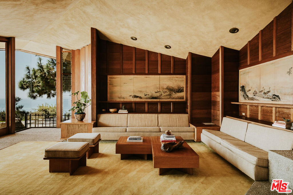 The Judge & Jeannie Anderson Residence, Aaron G. Green FAIA (1959). An oceanfront estate property of nearly 3.5 acres with magnificent views of the Pacific Ocean, Abalone Cove, and Catalina Island. One of Frank Lloyd Wright's most talented and original disciples, Green ran his own distinguished practice while serving as Wright's West Coast representative from 1951 until the elder architect died in 1959. The Anderson Residence is one of Green's finest works- an important and almost entirely intact example of his Organic Modernism. "True, there is a roof overhead, and there are walls and mullions supporting it," Curtis Besinger wrote for House Beautiful Magazine (1963). "But these do not seem so much to shut in and contain the space as to shelter it, give it definition, and suggest its use. ...The inside and outside have been conceived and planned as one continuous area." While deeply influenced by Wright's work and teachings, Green exhibited his own masterful and expressive architectural vocabulary in the Anderson Residence. The procession of space begins with a deeply recessed entryway. Once inside, a V-shaped plan directs sharply gabled rooflines outward in two directions; they seem to float above the living space. A private bedroom wing is to the left, and the more public spaces- living room, dining room, and kitchen- are straight ahead. Sweeping ocean views reveal themselves unexpectedly. There are areas of dramatic openness; others are more intimate and withdrawn. Two guest bedrooms and both baths face northeast towards a serene and private Japanese garden. In the primary bedroom, a wall of windows frames head-on ocean views. The apex of the room's corner opens completely to the outside by way of two monumental glass doors, and a quarried stone fireplace flanks the bedside. At the opposite end of the home, the kitchen is disguised as fine furniture, blending seamlessly with myriad built-ins throughout. From a central dining area, steps follow the contour of the land down to a sunken living room with original built-in seating and architect-designed furniture. A massive stone fireplace anchors the space, with adjacent mitered corner glass walls offering unobstructed panorama. Architect Eric Lloyd Wright oversaw a 2003 primary bath expansion, swimming pool update and spa tub addition with reverence to the harmonious design of the home and its surrounding terraces, planters, and gardens. With the adjacent canyon and Abalone Cove to the east, and several hundred feet of Pacific Ocean frontage to the south, the Anderson Residence offers an incredible degree of privacy and space. A study in serenity.