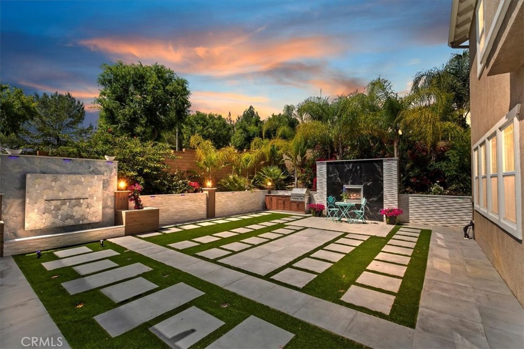 Absolutely Stunning 3,333 Sq Ft Estate in The Retreat – Corona’s Premier Gated Community! Nestled on a peaceful cul-de-sac within The Retreat, this exceptional residence showcases timeless architecture, no-expense-spared owner has spent more than $275,000 on recent high end finishes, and the home has a thoughtfully designed floor plan perfect for modern living. This exquisite home offers 4 bedrooms, a spacious loft/game room, and a chef’s dream island kitchen—complete with quartz counters, double ovens, white cabinetry with glass inserts, designer pendant lights, a built-in desk, a walk-in pantry, and under-cabinet accent lighting. Step through the elegant double-door entry into a grand living space featuring a step-down living room, formal dining room, large family room with a gorgeous porcelain tile fireplace, and a large laundry room with sink. Upstairs, the master suite is a true retreat, boasting a coffered ceiling, dual walk-in closets, and a spa-like bath adorned with marble and porcelain finishes on the vanities, tub, and shower—designed for pure indulgence. The Zen-inspired backyard is an entertainer’s dream, complete with a beautiful marble fountain, porcelain fireplace, all marble walls, brand-new built-in BBQ, full-size patio cover, and LED accent lighting that sets the mood throughout. Additional luxury features include:Mosaic-tiled front porch with fountain, Plantation shutters, crown molding, Egyptian crystal chandeliers, elegant drapes, 10,454 Sq/Ft lot with perimeter block walls, 3-car garage,and Breathtaking mountain views throughout the community. This is a once-in-a-lifetime opportunity to own a truly exceptional property in a sought-after location!