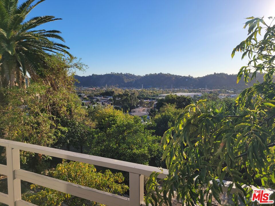 It's all about the view! Well, not really, as there's so much more this property has to offer than just the mesmerizing panoramic views! Located at the end of a long, private driveway, lies this starter compound featuring a very cool 2 bedroom plus den/study/office/guest bedroom, 2 bath modern, and a freestanding 1 bedroom, 1 bath guest house. The main structure is open plan, with walls of glass in the main living areas, master bedroom and bath, seemingly bringing the outdoors inside. The master features a walk-in closet and a bath with soaking tub, dual shower heads, and artful double vanity. Completing the main structure are high ceilings, bamboo/tile & vinyl flooring, fireplace, streaming sunlight into most rooms, as well as a large deck and rear yard. 1-car detached garage, as well as driveway parking for from 6-8 cars. Great property as it is, or turn this into the shangri-la of your dreams.