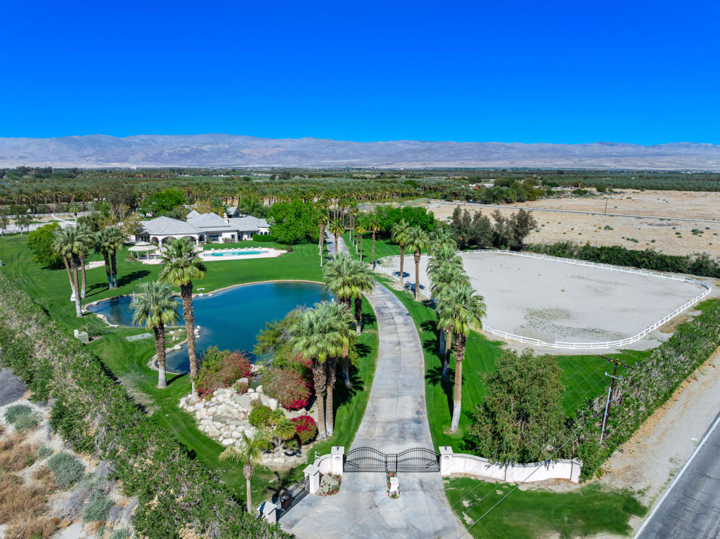 Beautiful equestrian compound! Great for horses, grand event or even your own personal estate. This approx. 9,131 SF home is located on 9.29 Acres. Enter through private electric gates and proceed up a meandering driveway past a large man-made lake with a beautiful waterfall to the main house. Step into the large foyer into an impressive living room with an oversized fireplace. The family room has a large bar and custom built-ins. Spacious kitchen with a large center island. The primary suite has dual walk-in closets (one with a large storage room attached), a powder/sitting room and an extra dressing room. The second primary suite has a living room, large walk-in closet and a full private bathroom. Each of the three guest suites have private full bathrooms. The main house has a large laundry room, wine cellar, cedar lined storage closet and a full dog kennel with a large built-in dog bath and fenced dog yard. There are four large garages with three very large storage rooms and a 5 gallon bottled water storage room. The guest house has three separate living quarters (studio and two 2 bedroom apartments) and two additional garages, one being a large RV garage. Additional property features include a huge covered patio, pool & spa, gazebo, two barns (one with caretakers quarters) with approx. 14 stalls, tack room with private full bathroom and a kitchen, multiple riding arenas, a large horse arena, pastures, an orchard and over 6 acres of turf. Many sitting areas with built-in benches throughout the property. There is a gym is with a full size multifunctional gym system, multiple closets and a large storage room attached. The orchard has its own well and is connected to the city as well. The possibilities are endless with this exceptional property. Total privacy abounds, yet you are only 2-4 miles from dining, shopping and schools.
