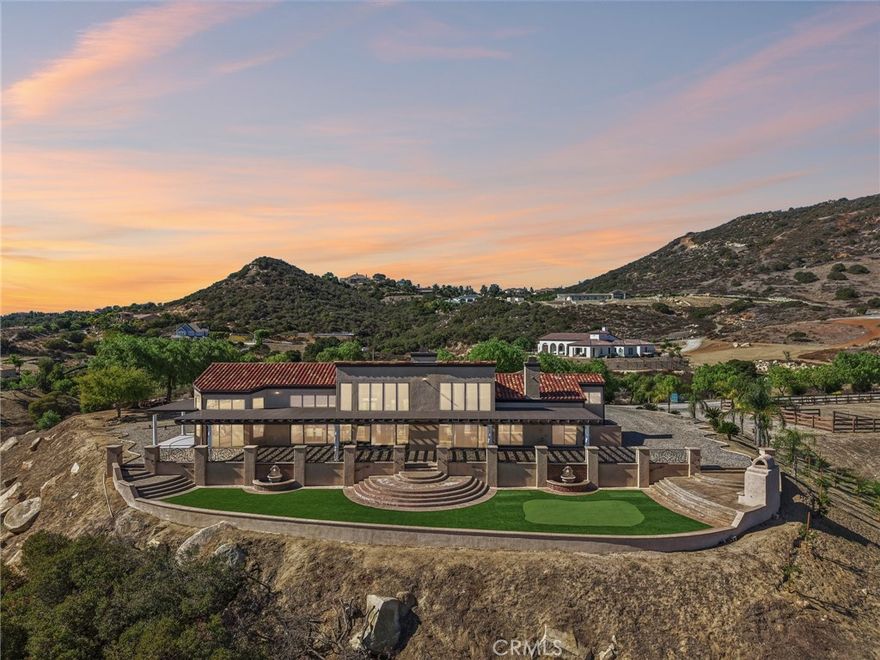 SINGLE-STORY LA CRESTA ESTATE on 10+ private acres with breathtaking panoramic views of the Bear Creek Golf Course, Santa Rosa Plateau, Temecula/Murrieta Valleys, Mount San Jacinto, and sparkling city lights. A private gated driveway sets a grand arrival to this serene, luxury retreat.

Enjoy Semper Solaris solar backed up by two Tesla Powerwalls, plus 33 guava trees—including strawberry, white, lemon, and pineapple varieties—with room to expand your orchard or plant a vineyard.

The expansive great room boasts dramatic ceilings, picture windows, and seamless indoor–outdoor living. The entertainer’s kitchen showcases an 18-ft granite island, premium appliances, two sinks, two stovetops, two microwaves, and two dishwashers, with elegant custom cabinetry and abundant storage.

Flexible layout with 4 bedrooms plus formal dining/office, and potential for a separate-entry suite. The spa-inspired primary bath features a luxurious double walk-in shower. The bedrooms feature upgraded porcelain tile flooring, combining style, comfort, and easy maintenance.

Recent upgrades include new skylights, new roof underlayment, exterior re-stucco and paint, replaced capstones on the terraces, new patio with architectural pillars and an Elitewood Ultra heavy-duty cover with Kynar 500 coating, and new outdoor lighting fixtures.

Outdoor living spans over 5,000 sq. ft. of terraced space with an outdoor fireplace, putting green and flag area with AstroTurf, and ample parking for guests and vehicles.

The property is horse-ready with stalls, arena, and access to extensive horse trails, plus space for a barn, guest house, or other amenities.

Additional features include two heating and cooling units for zoned comfort.

Luxury, privacy, usable land, and unforgettable views—this rare La Cresta estate combines elegant living with the natural beauty of Southern California.