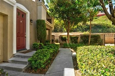 Beautifully remodeled upper end-unit located in the gated community of Altura. This 2 bedroom, 2 bathroom home offers newer flooring and paint in neutral tones, abundant natural light, and soaring ceilings that create a spacious and inviting atmosphere. The open layout features a living room with fireplace, a dining area, and an updated kitchen with granite countertops, custom backsplash, and newer appliances. Both bathrooms are fully upgraded, including a primary suite with dual vanities, a large step-in shower, and a built-in walk-in closet. Additional amenities include central heating and A/C, tile flooring, convenient inside laundry at the main level, and a direct-access garage.