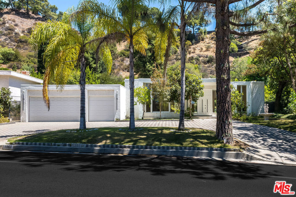 Located in the highly coveted Trousdale Estates, this 4 Bedroom, 5 Bathroom mid-century modern home offers the perfect balance of privacy and sophistication. Expansive living spaces with soaring ceilings and walls of glass create seamless indoor-outdoor flow, filling the home with natural light and showcasing views of the serene backyard and sparkling pool. The elegant living room with fireplace opens to multiple entertaining areas, while the gourmet kitchen with breakfast nook overlooks lush grounds. A spacious family room provides additional comfort and versatility. The luxurious primary suite boasts a spa-like bath and generous closets, with well-appointed secondary bedrooms offering comfort and privacy. A large motor court and attached garage provide ample parking. Just moments from world-class shopping, dining, and entertainment, this rare Trousdale retreat embodies timeless style and the ultimate Beverly Hills lifestyle.