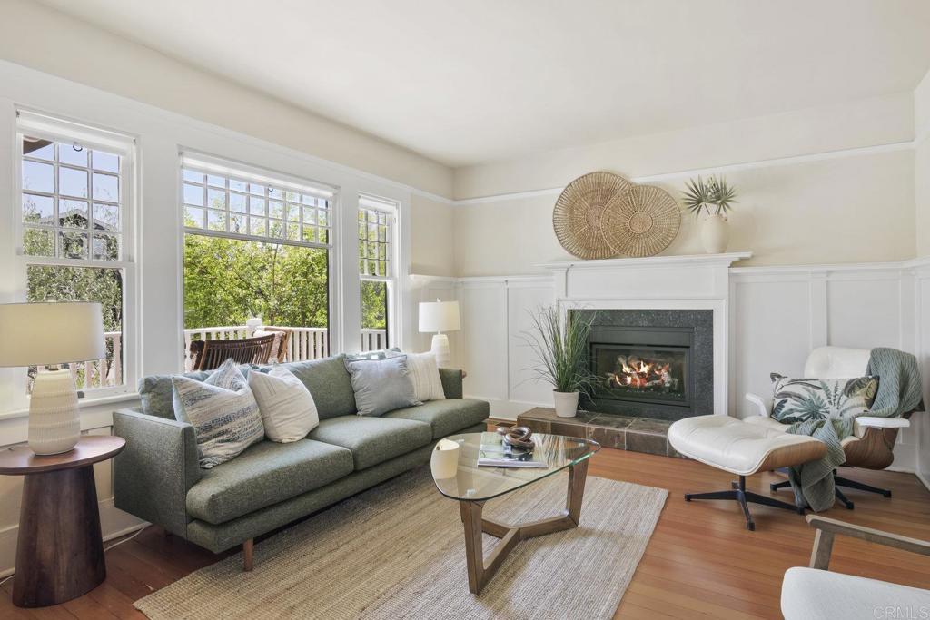 Balance neighborhood connection with a true sense of privacy in this North Mission Hills Craftsman. Set on a charming street just blocks from the West Lewis and Goldfinch commercial districts, this modernized home offers owned solar, a 200-amp electrical panel, NEMA 450 outlet for EV charging capability, updated HVAC, a reinforced foundation with updated drainage, and new roofs, all while preserving the character of its 1912 origins with a full-length front porch, double-hung windows, picture molding, paneled walls, and original wood floors. To the left of the formal entry is the light-filled living room, complete with a rebuilt fireplace and paneled walls. Through the glass french door, you’ll find a reading room or office that connects to a vintage full bathroom with claw-foot tub and hexagon tile floor. To the right of the entry, the dining room is highlighted by paneled walls, built-in shelving, drawers, and bench seating with storage, and opens to a modern eat-in kitchen with 2 pantries, quartz counters and island. Visible and accessible from the kitchen, the backyard is the highlight of this property. A private, oversized sanctuary framed by a mature pine hedge, features raised garden beds, a grassy play area, and a pergola for outdoor dining. Spending time here will truly become an extension of daily life. A detached 10' x 12' structure offers flexibility as an office, gym, or studio, while the 2-car garage with alley access adds convenience and future development potential. Upstairs, two large bedrooms each open through double French doors to private balconies and include extra-large walk-in closets. The versatile bathroom configuration allows for a primary ensuite or a shared bath without sacrificing privacy. Come experience this home for yourself and see why Mission Hills is one of San Diego County’s most coveted historic neighborhoods, with easy access to the airport, downtown, Coronado, beaches, and top universities.