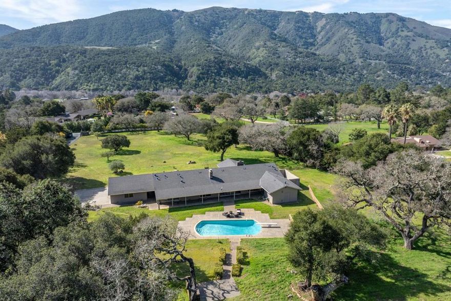 Ideally situated in one of the best locations in Carmel Valley, this classic ranch-style home with 5 bedrooms, an office, 4 full baths and a pool is set on ~3 acres of flat pasture with beautiful, mature oak trees and stunning views of the majestic Santa Lucia mountains. This single-level home with a gated driveway is perfectly designed to enjoy the indoor-outdoor Valley lifestyle, with patios, room for gardens, and large windows to bring the sunshine and outdoors in. The spacious interior includes ~4,000 SqFt of roomy living space, a large kitchen with breakfast or casual dining space, a separate formal dining room, and large living and family rooms each with their own fireplaces. With a 3 car garage, equestrian capabilities, and room to expand, this rare Mid-Valley treasure is a rare find and ready to be enjoyed by the next lucky owners!