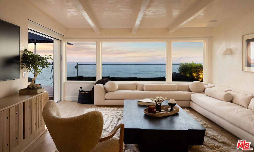 Nestled within the exclusive and historically rich Malibu Colony community, this newly designed beach-front house "Colony 88" by Saffron Case offers unparalleled luxury and privacy. Situated in a gated enclave with 24-hour security, this property spans 4,857 square feet across two levels, including a main house with three bedrooms and a detached guesthouse with an additional bedroom. Inside, find wide plank wood floors, cream plaster walls in living areas, and honed marble countertops in the chef's kitchen, which is equipped with high-end appliances, including a La Canche range and Subzero fridge. A sunny breakfast nook provides built-in seating. The living room includes a cozy fireplace, built-in bookshelves with a window seat, and a dining area. An additional family room puts the magnificent ocean views on full display. The primary bedroom suite provides exquisite oceanfront views through expansive windows and a private balcony. The attached bathroom includes a soaking tub and shower that look out to the sea.Outdoor living is equally impressive, with a spa, outdoor fireplace, fire pit, and a sunken Jacuzzi tub just steps from the sand. A grassy courtyard hosts a pizza oven and barbeque area, ideal for entertaining guests against the backdrop of ocean vistas. The deck leads directly to the beach.The detached guesthouse offers a serene retreat with its own living room, fireplace, bedroom suite, and lofted gym. A chic spiral staircase connects the two levels.Experience seamless indoor-outdoor living, enhanced with an indoor sauna. Malibu's renowned dining spots, shopping destinations like the Country Mart, and local hiking trails are moments away. This is a rare opportunity to own a piece of Malibu's coastal paradise, where luxury meets exclusivity in a coveted beachfront setting.
