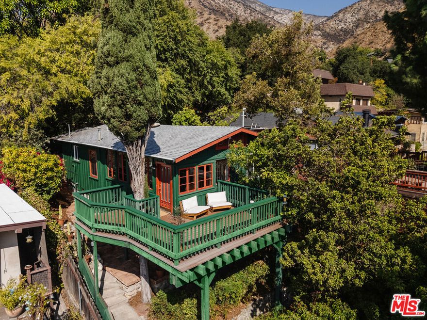 An enchanting blend of canyon charm and thoughtful updates, this 1922 Sierra Madre Canyon cottage offers a serene retreat tucked into the San Gabriel Mountains. A river rocklined driveway leads to a welcoming front porch that wraps around a towering cypress tree, creating a unique treehouse-like perch to enjoy the quiet setting and mountain air. Bathed in natural light, the living and dining room is framed by a wall of French windows that open to leafy canyon views. A cozy office with a built-in desk provides a tranquil space for work or creative pursuits. The kitchen balances vintage character with modern updates, featuring butcher block counters, a gas range, custom coffee cabinet, and ample workspace for cooking and entertaining. Two bedrooms and two baths span two levels, offering flexibility for guests, a home office, or a private retreat. The remodeled primary bath is finished with custom tile and a soaking tub. Outdoors, a flagstone patio extends the living space and creates an inviting backdrop for al fresco dining and gatherings. With its seamless indoor-outdoor flow, thoughtful upgrades, and tranquil canyon setting, this home captures the essence of California living. Tucked away in a peaceful location close to Mary's Market, local hiking trails, downtown Sierra Madre, and nearby Pasadena, it offers both retreat and convenience.