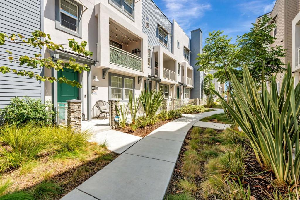 Beautifully designed 3-story townhome offering 4 bedrooms, 3.5 bathrooms, and 2,109 sq ft of thoughtfully planned living space. This is the largest floor plan in the community, featuring a smart layout ideal for modern lifestyles. The entry level includes a flexible bedroom with a full bath, perfect for guests, teens, or a private office. On the main level, enjoy an open-concept design that seamlessly connects the kitchen, dining, and living areas. With northwestern exposure, the space is filled with afternoon light. The kitchen features marble countertops, a full backsplash, a large island, stainless steel appliances, and a walk-in pantry. Upstairs, you'll find three additional bedrooms, including a spacious primary suite with a luxurious en-suite bathroom and a walk-in closet upgraded with $10,000 in custom features. A sleek laundry niche with built-in shelving and doors adds style and function. A full bathroom completes the top floor. Additional features include: tankless water heater, dual-pane windows, leased solar panels, and a finished 2-car garage with epoxy floors, built-in storage cabinets, and EV charger wiring installed just add your charger.