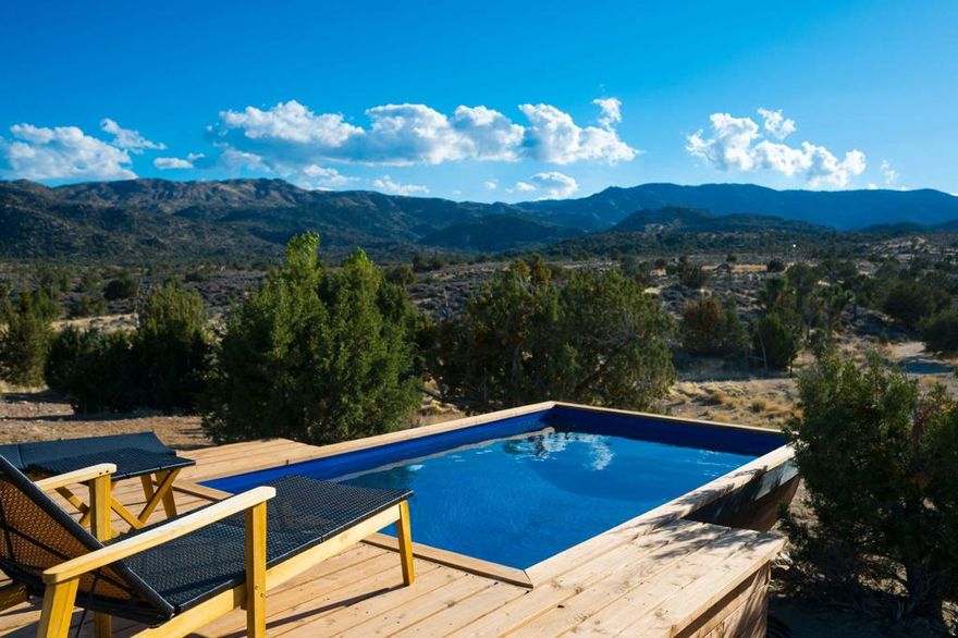 A storied 1935 desert ranch, reimagined for modern off-grid living amid one of the densest Joshua tree forests in the world.Welcome to Historic Thunderbird Ranch, an expansive 15-acre equestrian retreat spanning two APNs, surrounded by untouched BLM wilderness, where quiet, privacy, and wide-open horizon lines define the experience. This rare property lives self-sufficiently, powered by an owned solar array with well-fed, automated water storage and filtration, plus owned propane infrastructure, desert independence at its most complete.Crafted with artisan detail, the home blends rustic authenticity with elevated, textural finishes: antique hardwood floors worn beautifully with time, hand-poured concrete countertops, custom wood cabinetry, and patina-rich steel window frames that frame the landscape like shifting paintings. Updated appliances support everyday ease, while thoughtful additions shape a retreat rooted in wellness and wildness, an outdoor shower, infrared sauna, cold plunge, large cowboy pool, and wood-heated hot tub.Designed for equestrian lifestyle, the property includes established fencing and a riding ring, with room to expand, explore, or create. The surrounding land feels unspoiled and cinematic, rolling Joshua tree groves, granite formations, and the timeless silence of high desert open space.More than acreage, this is a legacy ranch, a self-reliant sanctuary built for connection to land, sky, and stillness.