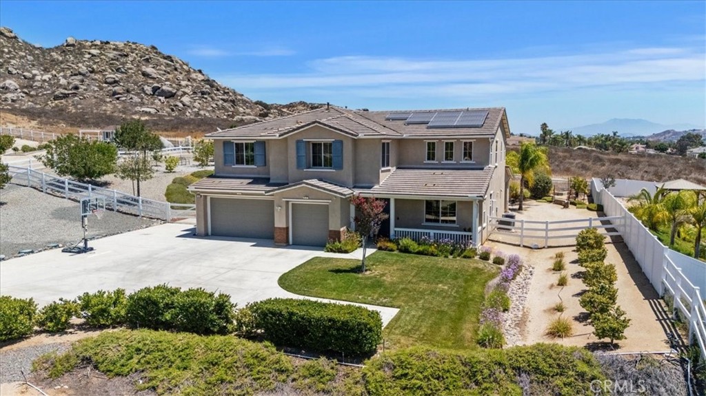 Nestled at the end of a quiet and secluded cul-de-sac in the highly desirable Bridle Creek neighborhood of Woodcrest, this stunning home offers the perfect blend of privacy, space, and upscale living. Situated on a sprawling one-acre lot, the property boasts a long private driveway leading to a beautifully maintained residence featuring 5 bedrooms, 4.5 bathrooms, and 3,787 square feet of thoughtfully designed living space. A formal entry with elegant wood flooring sets the tone, leading to a sophisticated dining room and a convenient butler’s pantry. Natural light fills the home through plantation shutters, highlighting the open-concept layout. The upgraded kitchen is a chef’s dream, complete with granite countertops, a custom tile backsplash, stainless steel appliances, a walk-in pantry, breakfast bar, and a sunny breakfast nook. The kitchen flows seamlessly into the inviting living room, with easy access to the expansive covered patio—an extension of your living space—perfect for entertaining or simply relaxing outdoors. The backyard is beautifully landscaped with mature palm trees, fruit trees, and elegant pavers, fire pit creating a serene and private retreat. A downstairs guest bedroom with a full bath offers comfort and privacy for visitors. Upstairs, you'll find three generously sized guest bedrooms with private baths, a spacious bonus room ideal for a home office, gym, or playroom, and a luxurious ensuite primary bedroom with His & Her Closets. The Ensuite bathroom featuring dual sinks, an upgraded separate shower, and a deep soaking tub. Additional features include custom paint throughout, a tankless water heater, water softener, full house generator, and solar panels that help lower electric costs. Tile roof with a three-car attached garage, and ample parking—including space for your RV add even more value and convenience. Don’t miss out on this beauty—it’s the perfect blend of elegance, comfort, and function in one of Woodcrest’s most sought-after communities!