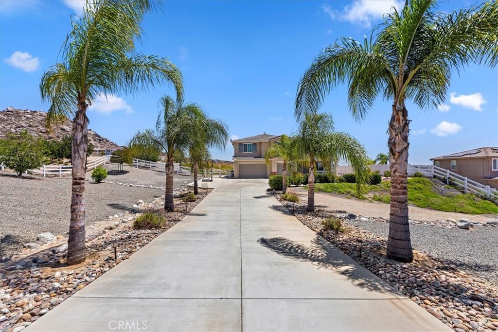 Nestled at the end of a quiet and secluded cul-de-sac in the highly desirable Bridle Creek neighborhood of Woodcrest, this stunning home offers the perfect blend of privacy, space, and upscale living. Situated on a sprawling one-acre lot, the property boasts a long private driveway leading to a beautifully maintained residence featuring 5 bedrooms, 4.5 bathrooms, and 3,787 square feet of thoughtfully designed living space. A formal entry with elegant wood flooring sets the tone, leading to a sophisticated dining room and a convenient butler’s pantry. Natural light fills the home through plantation shutters, highlighting the open-concept layout. The upgraded kitchen is a chef’s dream, complete with granite countertops, a custom tile backsplash, stainless steel appliances, a walk-in pantry, breakfast bar, and a sunny breakfast nook. The kitchen flows seamlessly into the inviting living room, with easy access to the expansive covered patio—an extension of your living space—perfect for entertaining or simply relaxing outdoors. The backyard is beautifully landscaped with mature palm trees, fruit trees, and elegant pavers, fire pit creating a serene and private retreat. A downstairs guest bedroom with a full bath offers comfort and privacy for visitors. Upstairs, you'll find three generously sized guest bedrooms with private baths, a spacious bonus room ideal for a home office, gym, or playroom, and a luxurious ensuite primary bedroom with His & Her Closets. The Ensuite bathroom featuring dual sinks, an upgraded separate shower, and a deep soaking tub. Additional features include custom paint throughout, a tankless water heater, water softener, full house generator, and solar panels that help lower electric costs. Tile roof with a three-car attached garage, and ample parking—including space for your RV add even more value and convenience. Don’t miss out on this beauty—it’s the perfect blend of elegance, comfort, and function in one of Woodcrest’s most sought-after communities!