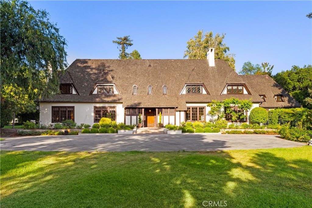 Welcome to one of Pasadena’s most extraordinary legacy properties, an architectural masterpiece blending historic English Arts & Crafts design with thoughtful modern updates, nestled on over 3.5 acres of flat and gated grounds in the prestigious South Arroyo neighborhood of SW Pasadena.
Originally built in 1915 by renowned architect Stiles O. Clements who designed the Hollywood Park Racetrack and Beverly Hills High School, this grand English Revival estate, also known as the Chandler House, was later expanded in 1931 by Kenneth A. Gordon and served as the 50th Annual Pasadena Showcase House of Design in 2014.
With nearly 12,000 square feet of combined living space, including close to 9,000 square feet in the main residence and nearly 1,300 square feet in the restored two-story carriage house, this estate offers both grand scale and architectural integrity. The home underwent a meticulous, top-to-bottom restoration in 2021–2022, blending timeless craftsmanship with modern comfort and convenience. Inside the main house, the signature architectural details include a 24x40 redwood-paneled Great Room with hand-hewn beams, leaded glass windows, a massive fireplace, and oak floors. The home features 6 bedrooms and 9 bathrooms, with 4 en-suite bedrooms upstairs, as well as cozy family spaces, a TV lounge, a spacious laundry room, and a remodeled third-floor flex space. A stunning modern kitchen with Viking appliances, a breakfast area, and an adjacent formal dining room providing an excellent space for hosting gatherings, celebrations, and memorable holiday parties. The re-designed wine cellar and tasting room on the lower level are perfect for hosting in style. Beyond the main residence, the beautifully restored two-story carriage house comes equipped with a guest room, bathroom, kitchenette, sitting area and it’s own private entrance.
Step outside into a private botanical paradise. including a pool with bathhouse, outdoor kitchen with BBQ and sound system, lily pond with water fountain, rose garden, and much more. a rare spring-fed well system updated in 2022 that supplies irrigation through three holding tanks.
This is more than a home, it’s a private retreat with a rich legacy, conveniently located close to the Rose Bowl, San Rafael Bridge, DTLA and minutes from all Pasadena has to offer. A Rare Opportunity to own a timeless estate of scale, privacy, and provenance, beautifully preserved and ready to begin its next chapter.