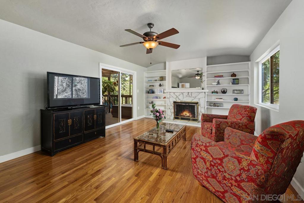 Location, Location, Location! First time on the market since 1966, this Mt. Helix property is on nearly an acre of land, fenced and gated for privacy. Built in 1936 by Abbott & Huston, with numerous upgrades, the 2,023 sq ft. home offers 3 bedrooms—each with walk-in closets—2 remodeled baths, and a full basement with separate entrance and bath which could be used as a hobby area, playroom, or even a rental or in-law suite. An updated kitchen, with skylight and solid wood cabinetry, flows into the great room with vaulted ceilings, fireplace, view deck, and access to an enclosed patio. The property’s award worthy mature landscape is a peaceful and private garden paradise offering room to roam and featuring numerous varieties of trees loved by both nesting hawks and flocks of wild parrots. Along with a tea house, custom potting area, barn/tack room, and detached 2-car garage, the property can accommodate RVs, trailers, and toys. The home has a new GAF Title 24 compliant roof, owned solar array with battery backup, and an upgraded electrical panel (2023). Additional improvements include: sewer lines, water heater, flooring (carpet, LVP, and refinished hardwood), LED lighting, fixtures, and garage door. Zoned for animals, the property embraces the area's agrarian lifestyle.
