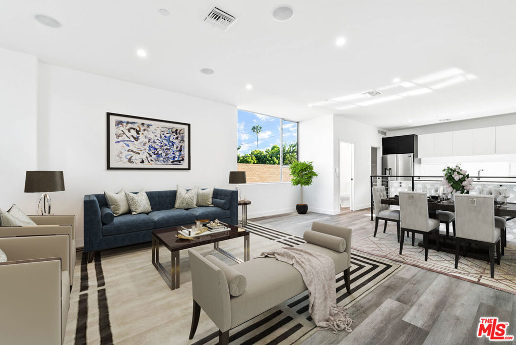 The Wilton Court is an intimate community of four homes built in 2020, located in the sought-after Third Street School District of Hancock Park. This residence offers over 1,780 square feet of modern living space, along with a two-car tandem garage equipped with an EV charger. The second floor includes a primary suite with a large walk-in closet and a spa-like bathroom, plus a second en suite bedroom. The third floor features an open living and dining area with a balcony that offers hillside and Griffith Observatory views. The kitchen includes a breakfast bar, pantry, dumbwaiter, and Samsung appliances. The top floor has a guest bedroom, full bath, and a flexible space ideal for a home office or den with views of the Hollywood Sign. A private rooftop deck with a built-in BBQ and sink provides city and sunset views, great for relaxing or entertaining. Additional features include built-in speakers on the main level and rooftop, a gated driveway, and a tankless water heater. Conveniently located near Larchmont Village. *Property pictured is a mirror of the actual property next door. Photos are virtually staged.*