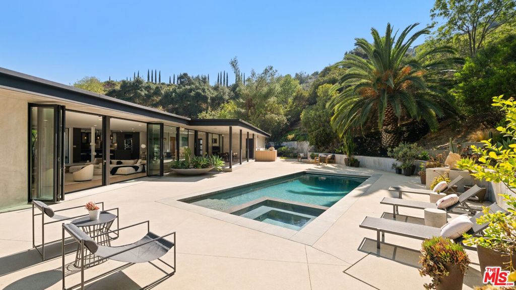 Over 1 acre private compound, fully secluded, completely remodeled mid-century contemporary home with all the latest and greatest amenities. This estate offers the perfect fusion of refined global design, ultimate privacy, and seamless California indoor-outdoor living. Incredible finishes curated from around the world enhance every corner of this 6-bedroom, 7-bathroom residence, creating a timeless yet modern sanctuary. Features include dual private primary suites, a chef's kitchen outfitted with premium Thermador and Viking appliances, smart home automation, full solar power with backup generator, a custom theater, and a state-of-the-art gym. The lush, private backyard is a true retreat, featuring a sparkling pool and spa, outdoor BBQ island, cozy firepit, and a versatile sports court. With its striking architecture, open flow, curated finishes, and coveted Beverly Hills location, this home is truly a Legacy Estate!