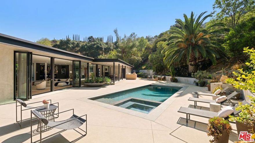 Over 1 acre private compound, fully secluded, completely remodeled mid-century contemporary home with all the latest and greatest amenities. This estate offers the perfect fusion of refined global design, ultimate privacy, and seamless California indoor-outdoor living. Incredible finishes curated from around the world enhance every corner of this 6-bedroom, 7-bathroom residence, creating a timeless yet modern sanctuary. Features include dual private primary suites, a chef's kitchen outfitted with premium Thermador and Viking appliances, smart home automation, full solar power with backup generator, a custom theater, and a state-of-the-art gym.  The lush, private backyard is a true retreat, featuring a sparkling pool and spa, outdoor BBQ island, cozy firepit, and a versatile sports court. With its striking architecture, open flow, curated finishes, and coveted Beverly Hills location, this home is truly a Legacy Estate!