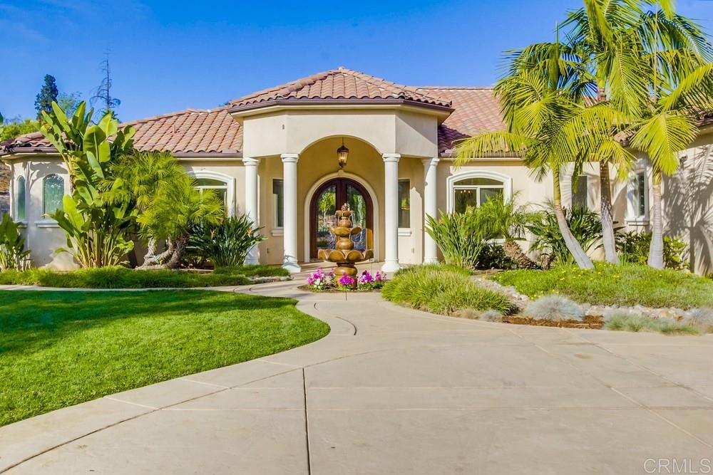 Exceptional single-story home on 1.5 acres in the exclusive gated community of Buena Creek. Includes a private detached casita—perfect for guest house, rental income, or pool house. Built with craftsmanship and high-end finishes, this home features over 3,500 SF with hardwood and stone floors, new carpet in bedrooms, solid alder wood doors, crown molding, and custom stonework in all bathrooms and showers—showcasing attention to detail. An arched glass entry door imported from Brazil makes a dramatic first impression. The chef’s kitchen boasts alder cabinetry, stone countertops, a center island, professional-grade appliances, and a built-in refrigerator—all open to the family room with sliding glass doors that lead to the beautiful tropical backyard and swimming pool. The open area for living and dining rooms adds flexibility and style, while glass doors lead to an office just off the entry. The luxurious primary suite includes dual walk-in closets, a jetted soaking tub, and a spa-style stone shower built for two. The expansive 700 SF covered patio is ideal for entertaining and enjoying the peaceful, private surroundings. The newly built lagoon-style pool features a raised spa and Baja ledge—perfect for relaxing and entertaining. Features OWNED SOLAR and a large lower lot area offers potential for RV parking, storage, or future expansion. Located in the scenic hills of Vista, this property combines elegance, privacy, and versatility in a sought-after neighborhood.