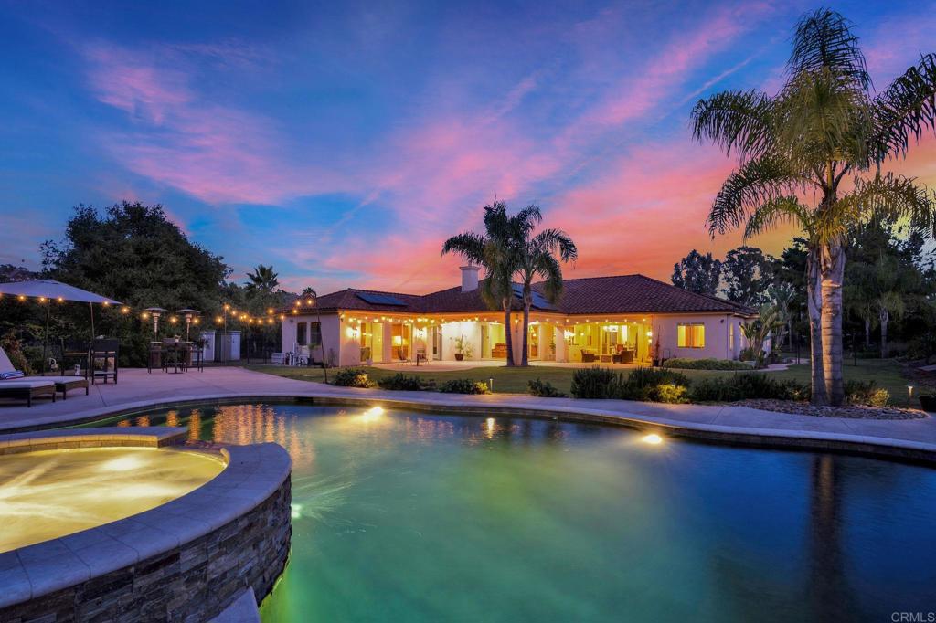 Price Reduced for the Exceptional single-story home on 1.5 acres in the exclusive gated community of Buena Creek. Includes a private detached casita—perfect for a guest house, rental income, or pool house. Built with craftsmanship and high-end finishes, this home features over 3,500 SF of hardwood and stone floors, plus new carpet in bedrooms. The solid alder wood doors, crown molding, and custom stonework in all bathrooms and showers—showcase attention to detail. An arched glass entry door imported from Brazil makes a dramatic first impression. The chef’s kitchen boasts alder cabinetry, stone countertops, a center island, professional-grade appliances, and a built-in refrigerator—all open to the family room with sliding glass doors that lead to the beautiful tropical backyard and swimming pool. The open area for living and dining rooms adds flexibility and style, while glass doors lead to an office just off the entry. The luxurious primary suite includes dual walk-in closets, a jetted soaking tub, and a spa-style stone shower built for two. The expansive 700 SF covered patio is ideal for entertaining and enjoying the peaceful, private surroundings. The newly built lagoon-style pool features a raised spa and Baja ledge—perfect for relaxing and entertaining. Features OWNED SOLAR and a large lower lot area offer the potential for RV parking, storage for all the toys. Located in the scenic hills of Vista, this property combines elegance, privacy, and versatility in a sought-after neighborhood.