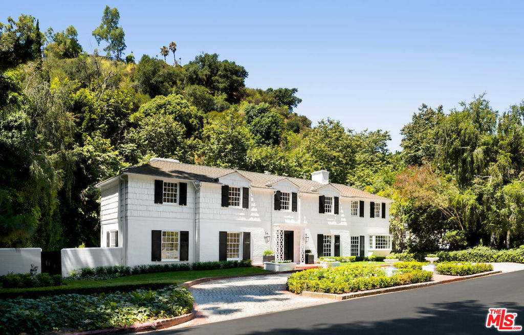 Meticulously remodeled East Coast Traditional on one of the most prestigious streets in Bel Air, just nine doors up from Hotel Bel Air. All 3,200+ SqFt of this sophisticated abode is crafted with only the finest finishes for the most discerning buyer. Upon entering the formal entry, guests are welcomed by rich hardwood floors and crown moldings thoughtfully leading through the curated floor plan. Designer done kitchen showcases marble countertops and floor to ceiling cabinets that tastefully conceal all appliances in addition to one of the four bedrooms in the home. The opulent primary suite offers a luxurious marble-clad en-suite with a soaker tub and dual sinks. A full basement with ample storage completes this masterpiece. Synonymous with tranquility, this ultra-private 30,000+SqFt lot is framed by lush greenery and boasts a sizable in-ground pool, fountains, and seating area; all of which can be admired by the enclosed sunroom. An extraordinary offering to acquire a lavish residence in one of the best locations in Los Angeles.