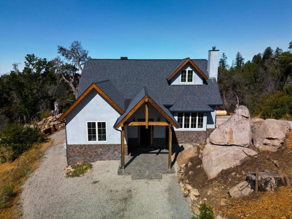 Wake up above the clouds in this peaceful Bonny Doon sanctuary, where modern design meets soulful craftsmanship. From the moment you step inside, you're surrounded by natural wood details, including reclaimed, live-edge trim and artisan-crafted countertops. Gaze out the expansive windows to catch ocean views, glowing orange sunsets, and star-filled night skies. Upstairs, the master suite feels like a retreat, with a deep soaking tub under a skylight, a curb-less walk-in shower, and a balcony that begs for morning coffee just steps from your personal beverage station/wet bar. Feel the warmth underfoot from the radiant heat flooring. In the winter, cozy up by the fireplace, and in the warmer months. The home is solar-powered, with battery backup, an EV charger, engineered septic, and a full fire sprinkler system. There are approved plans for a detached 2 car garage with a 1 bedroom ADU above offer long-term flexibility and rental potential. Includes a permitted yurt that could be a home office, artist studio, wellness space, or income-producing setup for retreats or rentals. Whether you're looking for a fresh start, a 2nd home, a weekend hideaway, or a home that honors the land while leaning into "what's next" this one is worth the drive up the mountain.