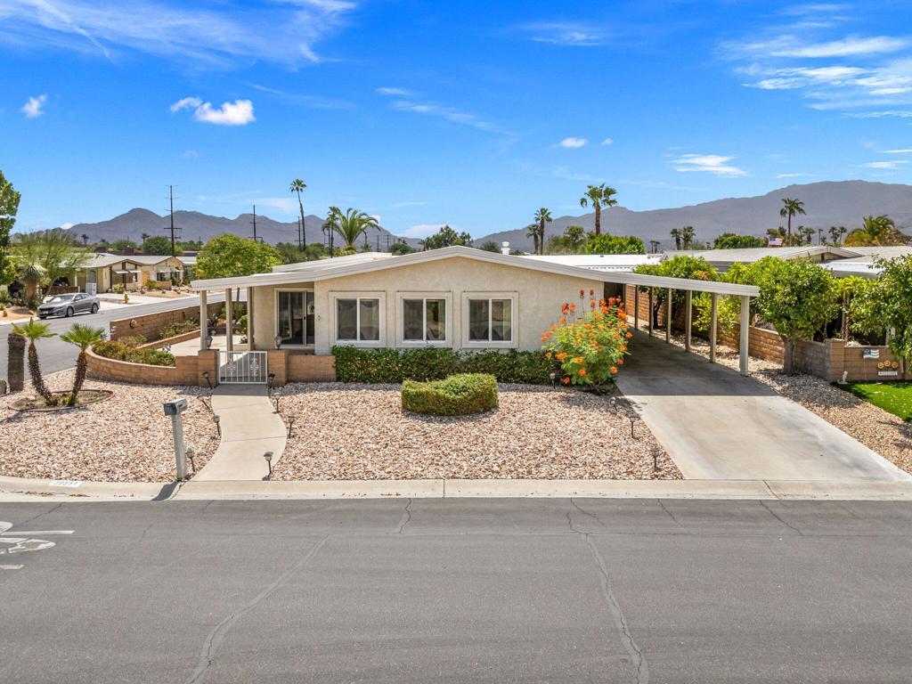 This 1,850 sq. ft. 2 bedroom, 2 bathroom home is truly one of the finest in Palm Desert Greens Country Club, showcasing upgrades throughout including light tones, textured walls, a spacious living room, separate dining area, large bar with its own sink, and an updated kitchen with beautiful quartz countertops. The home also offers a separate laundry room with washer and dryer plus direct access to the parking area. All windows and sliding doors have been replaced, and the pleasant outdoor space features both a tiled patio bar and private lounging areas. The spacious master suite includes a sitting area and mirrored his-and-hers closets, while the large corner lot provides exceptional privacy, two separate covered parking areas, and a golf cart enclosure. Ready for the new owner's final touches, this home offers a fantastic opportunity in one of the most popular 55+ active communities, where you OWN the land and enjoy a low $400 monthly HOA fee that includes 24/7 guard-gated security, cable TV, internet, trash service, FREE golf, and more--making it one of the very best values in the valley! Sold as is