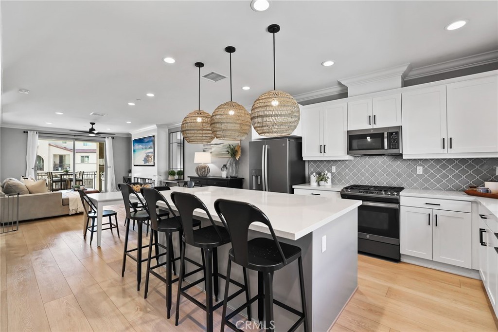Discover the Many Details and Stunning Upgrades complimenting this Modern 2021 Built Townhome. Located in the Gated Resort-Style community of Ironridge and featuring 4 Bedrooms + 3.5 Bathrooms this Stylish Residence has everything the Modern Day Buyer is looking for! A Light & Bright interior with Soaring Ceilings greets you upon entry to provide the perfect ambiance for your daily routine. The Highly Desirable Spacious Downstairs Full Bedroom Suite features Pre-Plumbed utilities for a Kitchenette, a spacious Full Bathroom, Living Room and its own Laundry Room! Designer Paint, Crown Molding, Decorative Trim, Wainscoting, Custom Rollershade Window Coverings and Luxury Vinyl Flooring Throughout the Home continue to set the tone for this Gorgeous Upgraded Residence. Upstairs you will find the heart of the home with the Luxurious Gourmet Kitchen featuring Neutral Quartz Countertops, Huge Center Island, Stainless Steel Appliances, Crisp White Cabinets, Designer Tile Backsplash, Convenient Coffee Bar, Charming Bay Window, and Designer Pendant Lighting. The comforts of an Open Concept Living Room are highlighted with High Ceiling, an abundance of natural light, Beautiful Covered Balcony and Custom 74" Fireplace Electric Fireplace creating your very own at home sanctuary. Upstairs you will find an 3 Additional Bedrooms, Including the Primary Suite and Spacious Laundry Room. Indulge within the Comforts of a Calm Atmosphere in your Primary Suite Retreat offering plenty of Space and Natural Light throughout. Continue into the Spa like Primary Bathroom with a Restorative Walk-in Shower, Dual Vanities, and Large Walk-in Closet. Additional Tech Upgrades for the Modern Buyer Include, Eero Mesh Wifi, Pre-Wire for EV charging (220V), Whole House Fan, Smart Home Features include Controlling Lighting, AC, Garage Doors, Front Door from your phone! The Premium Location of this property can not be overlooked with no buildings directly in front of the home, Putting Green Views, Convenient Access To Guest Parking & Walking Distance to Exclusive Resort Style Ironridge Amenities... Gorgeous Home...Come see this one in person!