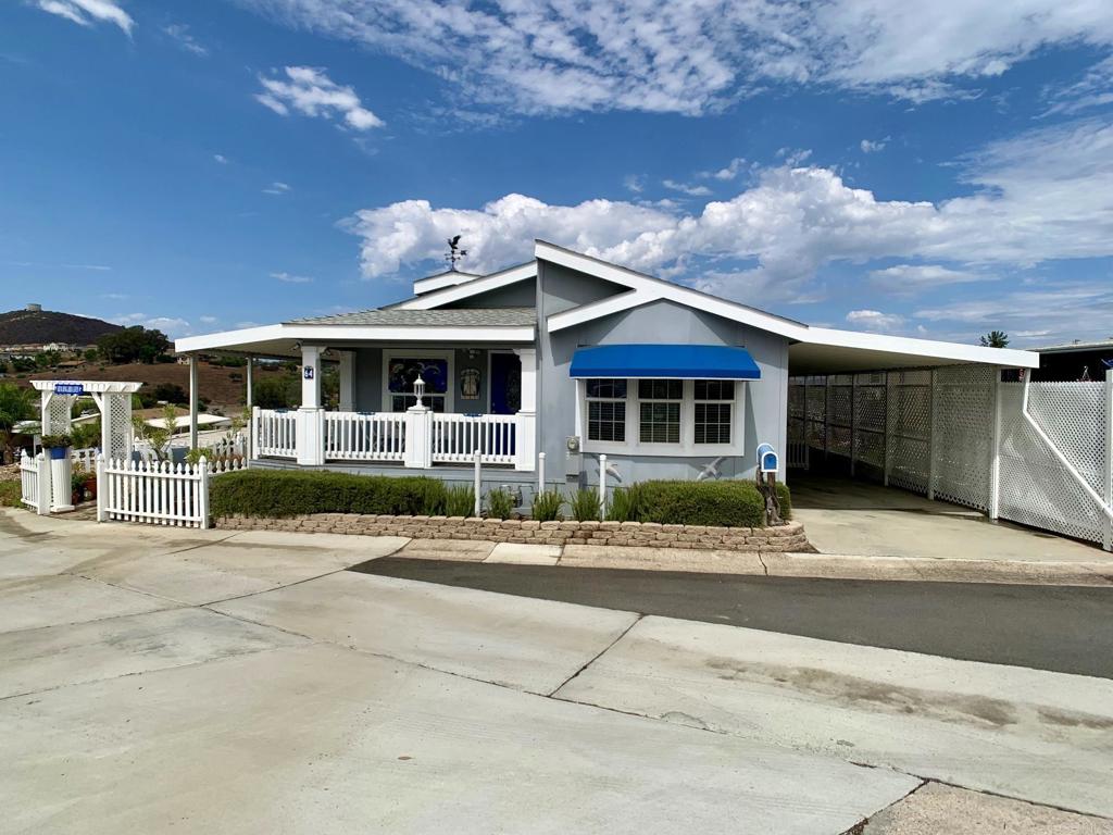 Welcome to this lovely home (largest, corner lot) located in a beautiful 55+ park in El Cajon! Centrally located for convenience to shopping, medical facilities and minutes from I8! This beauty offers 2 bedrooms, 2 bathrooms, den/study can be used as a 3rd bedroom, with a primary suite offering a walk in closet. Indoor laundry room, open floor plan, with newer roof (2 yrs) HVAC (4 yrs), freshly painted and kitchen remodel (1 yr). Low space rent of $1,280.00/month, includes use of community clubhouse and pool. This gem is a MUST see! You will love the beautiful porches around the entire front of this home! The views are stunning while having your morning coffee or tea and a glass of wine in the evening watching the beautiful sunsets!