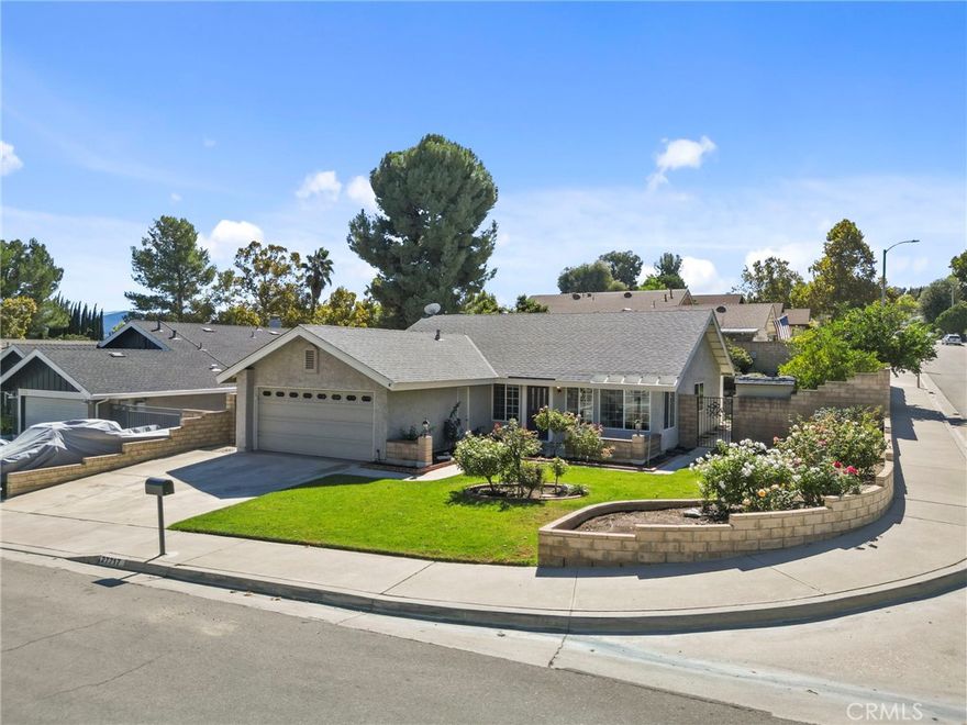 Charming Single-Story Valencia Home on a Beautiful Corner Lot. Welcome to this beautifully upgraded single-story home, nestled in a quiet, well-established Valencia neighborhood. Situated on a well-landscaped corner lot, this residence offers comfort, style, and exceptional outdoor living. Step inside to discover a thoughtfully designed floor plan that's perfect for entertaining. The remodeled kitchen is a true showstopper, featuring high-end Thomasville soft-close cabinetry, granite countertops, stainless steel appliances, and an abundance of counter space—all opening seamlessly to the main living areas. Enjoy the spacious living and dining room with vaulted ceilings, rich hardwood floors, and plenty of natural light—ideal for both everyday living and hosting family gatherings. Step outside to your private backyard oasis, complete with a covered patio, built-in BBQ, fire pit, and a terraced hillside adorned with mature, high-producing avocado and fruit trees. Retreat to the remodeled primary suite with a luxurious spa tub in the upgraded bath. This home also features numerous upgrades, including copper plumbing, dual-pane windows, and a newer HVAC system, roof, water heater, and main service panel. Additional highlights include a stand-up attic above the garage offering valuable storage space. Don’t miss this rare opportunity to own a move-in-ready gem in one of Valencia’s most desirable neighborhoods. Some photos have been virtually staged.