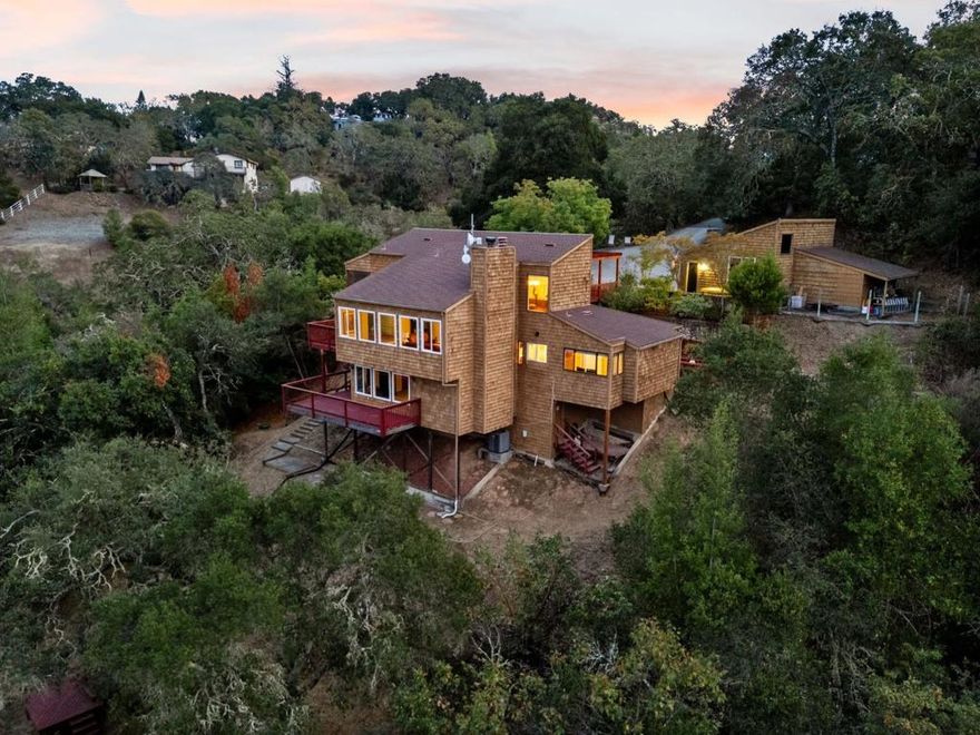 Welcome to 9040 El Matador Dr. A serene 3-acre retreat at the end of a quiet cul-de-sac in Gilroy, surrounded by nature's beauty and peaceful stillness. With panoramic views from nearly every room and five expansive decks, this home invites seamless indoor-outdoor living. Warm hardwood floors, granite slab countertops, and two fireplaces add charm inside, while the primary suite offers a jetted tub with stunning views perfect for quiet moments of relaxation. Thoughtfully designed to blend with the landscape, the property features a welcoming stone entry, an oversized 2+ car detached garage with a workshop and storage loft accessible with stairs, and expansive wooded grounds including a private shooting range. Just minutes from town yet feeling worlds away, this one-of-a-kind property offers unmatched privacy, natural beauty, and the best of peaceful country living.