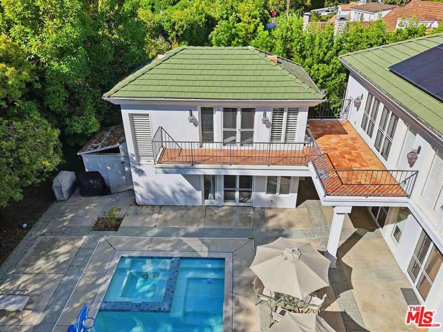 Exceptional two-story Beverly Hills Flats guest house offering bright, inviting living spaces and excellent privacy. The main level features an open living area with abundant natural light, recessed lighting, and wood-style flooring, along with a convenient kitchenette and full bathroom. The upper level includes a spacious bedroom with vaulted ceilings, a skylight, and French doors leading to a private balcony overlooking mature landscaping. Outdoor amenities include multiple seating areas and a well-maintained patio. Designed for comfort and seamless indoor-outdoor living, this residence is ideal for relaxation, extended stays, or guest accommodations.