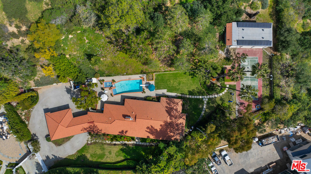 Magnificent Bel Air Estate. A long driveway off the street brings you to a gated estate of OVER 2 ACRES. Classic ranch-style home with 5 bedrooms, vaulted ceilings, and formal entry. Wide plank oak floors throughout. Sliding doors to an enormous, lush backyard that wraps around the home. Pool and spa with outdoor bathroom and sauna. ADDITIONAL 2-STORY structure for your GUESTHOUSE, gym or recording studio. In between the two structures is a PICKLEBALL court. RARE offering that should not be missed. Award-winning Roscomare Rd Elementary, Central location with easy access to Sunset and the freeways.
