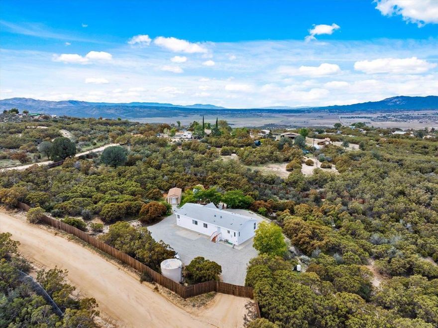 Take in breathtaking mountain views every morning with your coffee and end your day with glowing sunset skies from the large deck of this beautifully maintained home in Anza. Thoughtfully updated and exceptionally cared for, this property offers the perfect blend of comfort, function, and serene country living. Step inside to discover an inviting open layout with luxury vinyl plank flooring throughout the home, high ceilings, and abundant natural light that creates an airy, spacious feel throughout. The living area flows seamlessly into the dining and kitchen spaces, perfect for family gatherings and casual entertaining. The kitchen comes fully equipped with a brand-new stove, microwave, and dishwasher, along with a well-maintained refrigerator included in the sale. A dedicated laundry room provides extra space and privacy for daily chores. A charming breakfast nook near the kitchen and living room is versatile and can serve as a pantry, small home office, or additional storage area. The first bedroom welcomes you through French doors, adding a touch of charm and flexibility for use as a guest room, den, or even a creative workspace. The second bedroom offers a comfortable layout with its own closet featuring traditional hinged doors rather than sliders — a thoughtful detail that enhances accessibility and design. The primary suite is a relaxing retreat with a generous walk-in closet and a spacious bathroom featuring a separate shower, soaking tub, and double sinks — the perfect place to unwind after a long day. Outside, you’ll find newly painted exterior walls that complement the natural beauty surrounding the home. The large deck offers the perfect setting to enjoy Anza’s sweeping mountain views and tranquil evenings. The property includes ample parking space in the large driveway area — ideal for multiple vehicles, trucks, or recreational equipment. The extra storage sheds provide additional room for tools, outdoor gear, or gardening supplies. With plenty of open land, there’s room to create your own garden, workshop, or outdoor entertainment area. This home is on a permanent foundation with a recorded 433A — a valuable feature that offers peace of mind for buyers and lenders alike. Located conveniently close to the main road, this home offers easy access while still providing the peace and privacy of rural living. This well-kept property delivers comfort, beauty, and versatility — truly a remarkable home that stands out for its thoughtful design and pride of ownership.