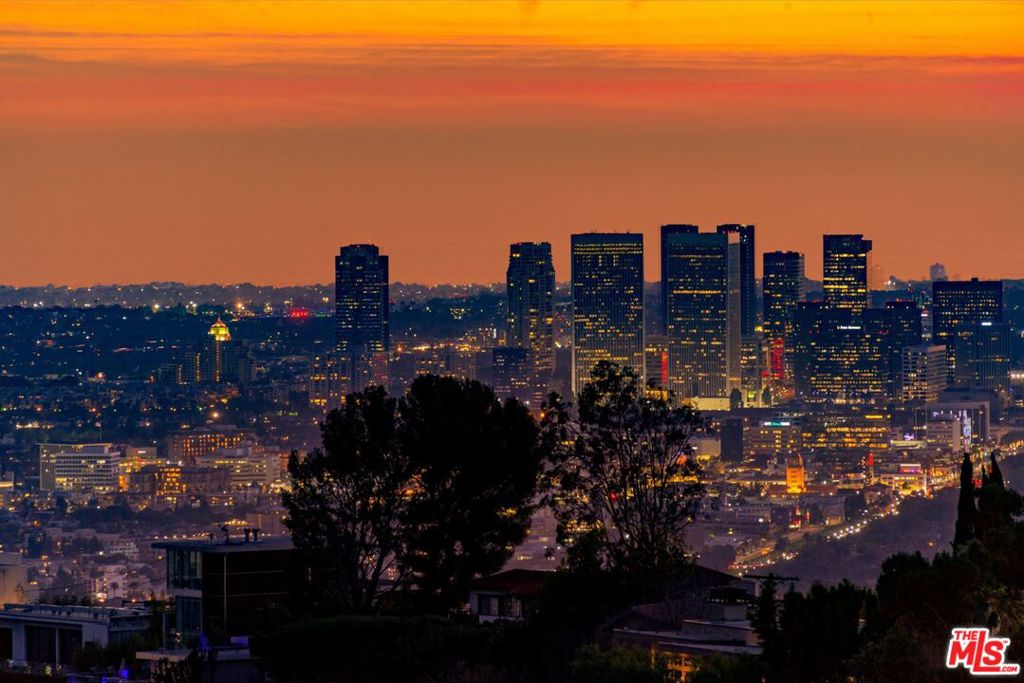 Incredible gated compound set on a rare and extraordinary flat ridge top overlooking the entire LA Basin from East of Downtown to the Ocean. 3 years to create this unique and uncommon environment with spectacular scale, design, high-quality finishes and attention to detail. Large open spaces flooded with natural light and entire walls of pocket doors. High ceilings throughout with expansive gallery. Formal living room with bookcases, fireplace, and incredible views. Gourmet kitchen/family room opens to pool and outdoor kitchen. Separate Media room, Master suite with sitting room, double closets/dressing room and gorgeous marble bath. 5 additional bedrooms ensuite all open to wraparound view terraces. Across the expansive lawn is a 4 room guest house/studio with 2 baths and desert garden along with private and direct access to miles of hiking trails. A rare opportunity to acquire this one of a kind property.