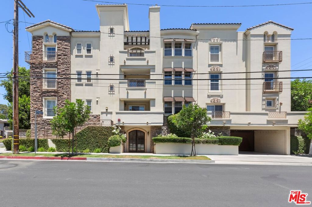 This stunning penthouse condo has 3 bedrooms, 3 bathrooms including 2 ensuite baths, and a large den/office with built-ins and French doors. The kitchen is well appointed with stainless-steel appliances and opens to an airy living room complete with a fireplace and dining area that flows out to a balcony with views of the mountains. The unit has high ceilings and large windows throughout which flood the space with natural light and frame spectacular views from every room. Generous storage, with high-quality built-ins, ample closets, two large walk-in closets, and a dedicated laundry closet housing a new washer and dryer, plus additional storage. The building itself is meticulously maintained, surrounded by lush greenery, and features a charming central atrium with a bubbling fountain. Residents can also unwind on the community rooftop deck, which offers lounge chairs and views of the city and mountains. The building sits in a picturesque residential enclave of Studio City close to the vibrant Studio City Village, filled with shops and restaurants.