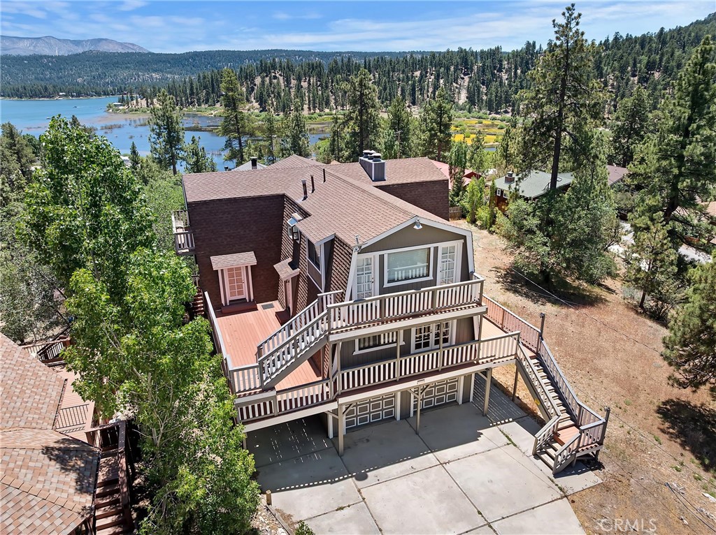 Luxury Mountain Retreat with Spectacular Views, 39325 Lodge Rd., Fawnskin, CA Welcome to your dream mountain escape perched above the treetops in peaceful Fawnskin. This stunning three-story home offers breathtaking, unobstructed views of Big Bear Lake, Snow Summit, Bear Mountain, and the majestic San Gorgonio Mountains. Whether you’re looking for a tranquil family getaway or a full-time residence this property delivers on all fronts. The main level greets you with soaring ceilings, a warm brick fireplace, and a bright, open floor plan perfect for gathering. The spacious layout includes a large living room, family room, chef’s kitchen, two bedrooms, and a beautifully remodeled guest bathroom. Every corner of this home was designed with comfort, charm, and livability in mind. Upstairs, a grand loft with a full wall of windows captures the surrounding natural beauty, perfect for a game room, home office, or additional lounge space. Just beyond, a cozy kitchenette leads to a private primary suite with its own fireplace and stunning views. The lower-level functions as a fully independent living space with its own entrance, full kitchen, game room, two bedrooms, and a guest bathroom ideal for guests, multigenerational living, or rental income potential. Three fireplaces throughout the home create a warm ambiance year-round. Recently remodeled from top to bottom with no detail overlooked, this home blends rustic elegance with modern upgrades. Situated on a generous 8,200 sq ft lot and offering approx. 3,720 sq ft of living space, there’s room for everyone and everything you love about Big Bear living Don’t miss this rare opportunity to own one of Fawnskin’s most exceptional view homes. Schedule your private showing today!