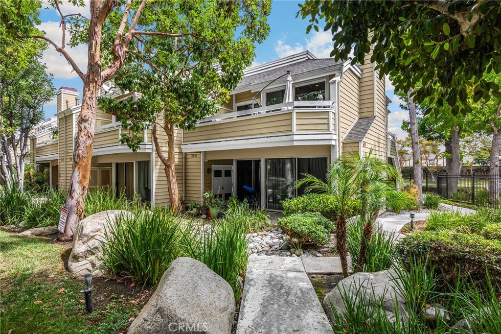 Fully renovated dual-primary bedroom condo in South Coast Springs with over $100,000 in upgrades. This two-bedroom, two-bathroom unit features dual ensuite bedrooms, ideal for privacy and flexibility. The entire interior has been gutted and rebuilt with premium finishes throughout. Highlights include a custom-built laundry closet relocated from the patio to the primary bedroom, accommodating a full-size stackable washer and dryer. The patio laundry closet is still intact if you want to move it back to side-by-side appliances. Designer shaker closet doors with mirrored panels and professionally organized interiors enhance both bedrooms. Custom tile work and quartz countertops elevate the kitchen and bathrooms, with one ensuite offering a shower and tub combination. Consistent laminate flooring in neutral gray tones flows throughout the home, complemented by plantation shutters and a dramatic stone-covered fireplace that extends to the ceiling. Located on the second floor, the unit enjoys high ceilings throughout—an architectural feature that adds volume and light, and is often a favorite among buyers. Additional upgrades include a newer water heater and central air conditioning for year-round comfort. Smart home features include a Nest thermometer. Enjoy views of the beautifully landscaped common area, reminiscent of a mountain retreat, with mature trees, natural stone accents, and lush ground cover that create a peaceful, forest-like ambiance. This unit includes a one-car garage with epoxy flooring, finished drywall, fresh paint, and custom cabinetry for storage. There is still ample space to park a small SUV or medium-sized sedan. The South Coast Springs community offers two pools and a prime location near world-renowned South Coast Plaza, Segerstrom Center for the Arts, and South Coast Repertory. Residents also enjoy easy access to fine dining, boutique shopping, parks, and major freeways, making this community as convenient as it is desirable.
