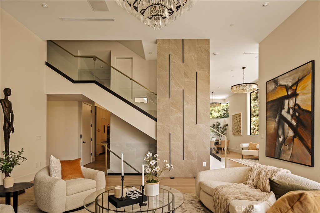 Recently completed, this custom-curated modern showpiece is the epitome of Los Angeles luxury. Perched above the city near famed Runyon Canyon and Wattles Garden Park, this entertainer’s dream offers sweeping south-facing city views and tranquil easterly canyon vistas—perfect for capturing unforgettable sunrises and sunsets.
No expense was spared in crafting this architectural gem, where soaring 13-foot ceilings and walls of glass frame the breathtaking panorama, and over 2,500 square feet of outdoor deck space invites you to live and entertain among the clouds. The rooftop retreat elevates outdoor living with a hotel-style pool featuring a swim-up bar and cascading waterfalls—creating an idyllic, resort-like experience that transports you to paradise. A spa, built-in outdoor kitchen, and grassy yard area complete this unmatched private oasis floating high above the sparkling city lights.
A thoughtful blend of timeless, organic elements speaks to the nature that surrounds and flows within the home. Seamless white oak floors, a stunning 10 ½-foot Brazilian Crystal Quartzite kitchen island, and a sculptural gray stone soaking tub evoke a sense of grounded luxury, bringing the outdoors in with elegance and ease.
A private elevator services all levels, including a rare 6-car garage, offering ultimate convenience and security. Sexy, modern, and meticulously designed, this home is a true entertainer’s showpiece—perfect for those seeking to embody the ultimate LA lifestyle in a serene, elevated setting.