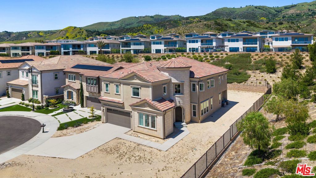 Welcome to this stunning, professionally designed Toll Brothers estate located in the prestigious, guard-gated community of Porter Ranch. This exceptional 5-bedroom, 6-bathroom luxury residence offers impeccable craftsmanship, high-end upgrades, and refined architectural elegance throughout. Privately situated at the end of a quiet cul-de-sac, the home sits on one of the largest lots in the community at just under 20,000 square feet; offering both privacy and incredible potential. The lot is currently unfinished, providing endless opportunities to customize your own gorgeous and spacious indoor-outdoor living retreat, complete with space for a pool, outdoor kitchen, entertainment areas, or lush landscaping.The exterior showcases Mediterranean-inspired design with a turret-style grand entry and timeless stone accents. Inside, you're greeted by a dramatic herringbone-patterned hardwood floor entryway, soaring ceilings, and expansive windows that bathe the home in natural light. The gourmet kitchen is a culinary dream, outfitted with Sub-Zero and Wolf appliances, custom cabinetry, quartz countertops, and double islands while an additional gourmet prep kitchen provides the ideal setup for entertaining. The open-concept layout flows into elegant living and dining spaces, complemented by a Beam central vacuum system, smart home wiring, and designer lighting and finishes throughout.Upstairs, the spacious primary suite serves as a private retreat with a cozy gas fireplace, a serene patio, and a spa-inspired bathroom featuring three rainfall shower heads, dual vanities, and his-and-hers walk-in closets. All secondary bedrooms feature en-suite, providing comfort and privacy for family and guests. Enjoy two premium built in 5.1 surround sound systems and a total of 22 speakers throughout home. The attached two-car garage includes an upgraded epoxy floor and additional space for storage. This remarkable home is located near top-rated Porter Ranch Community School, scenic trails, and the upscale shops and restaurants at the Vineyards at Porter Ranch. With its oversized lot, luxurious design, and unbeatable location, this is a rare opportunity to own a true showpiece in one of the most desirable communities in Los Angeles.